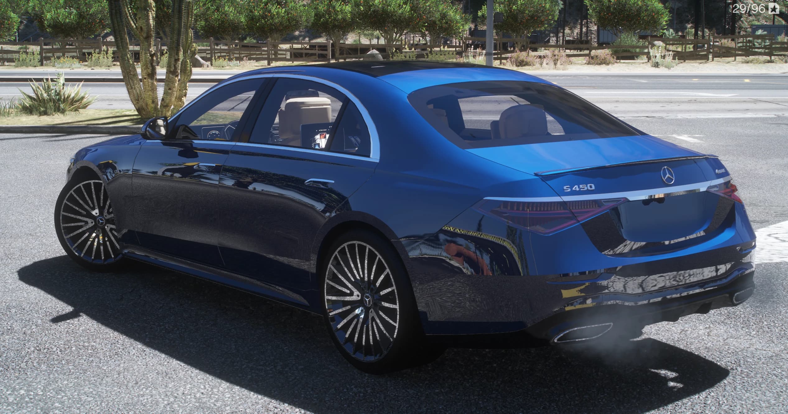 Rear three-quarter of the blue S450 with the S 450 and 4MATIC badges, the Mercedes star and connected LED taillights