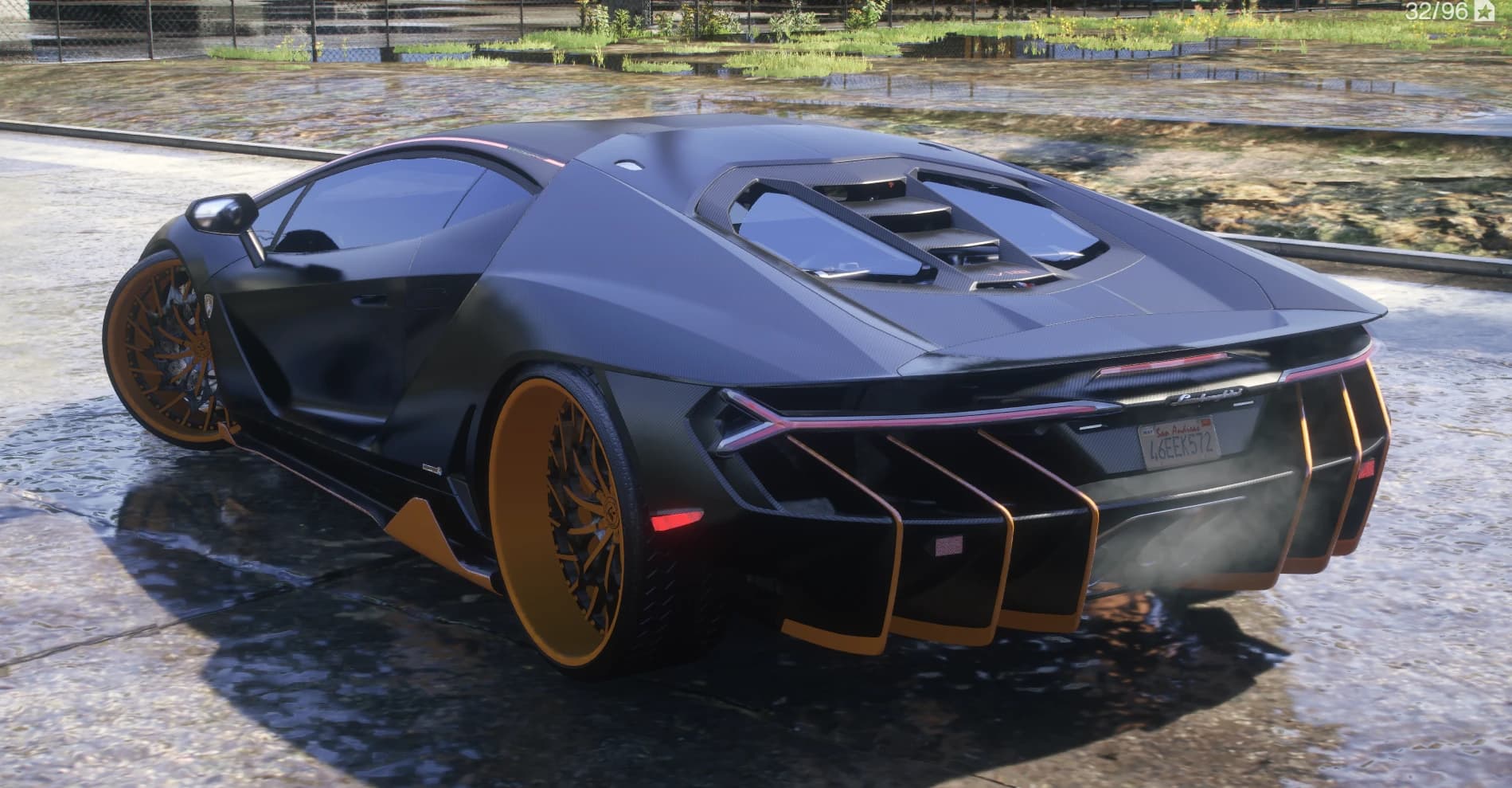 Rear three quarter view showing the glassed carbon engine cover, full width taillight strip and the huge diffuser fins edged in orange