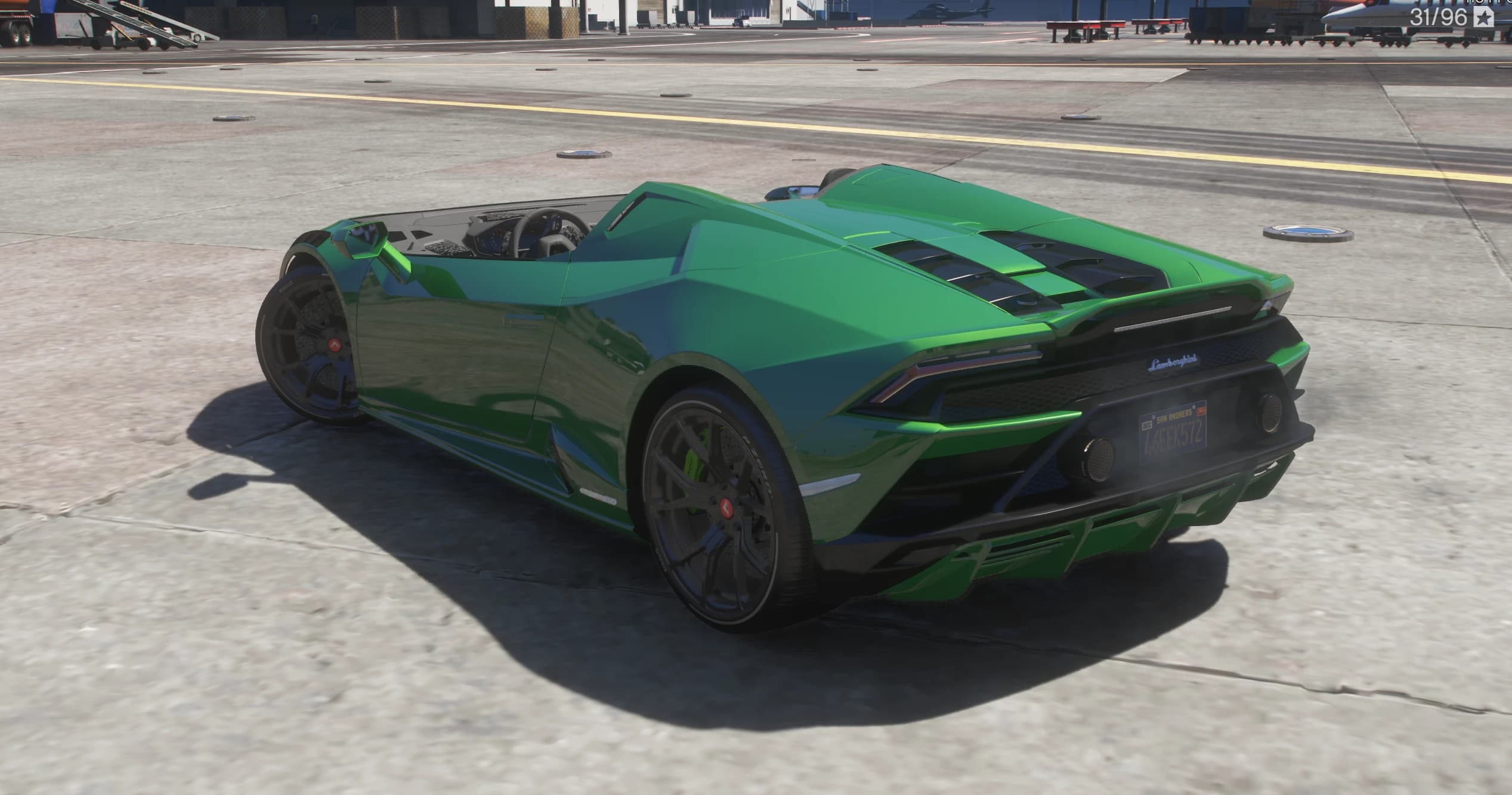 Rear three quarter view showing the slatted engine cover, hexagonal mesh valance, twin round exhausts and full width diffuser