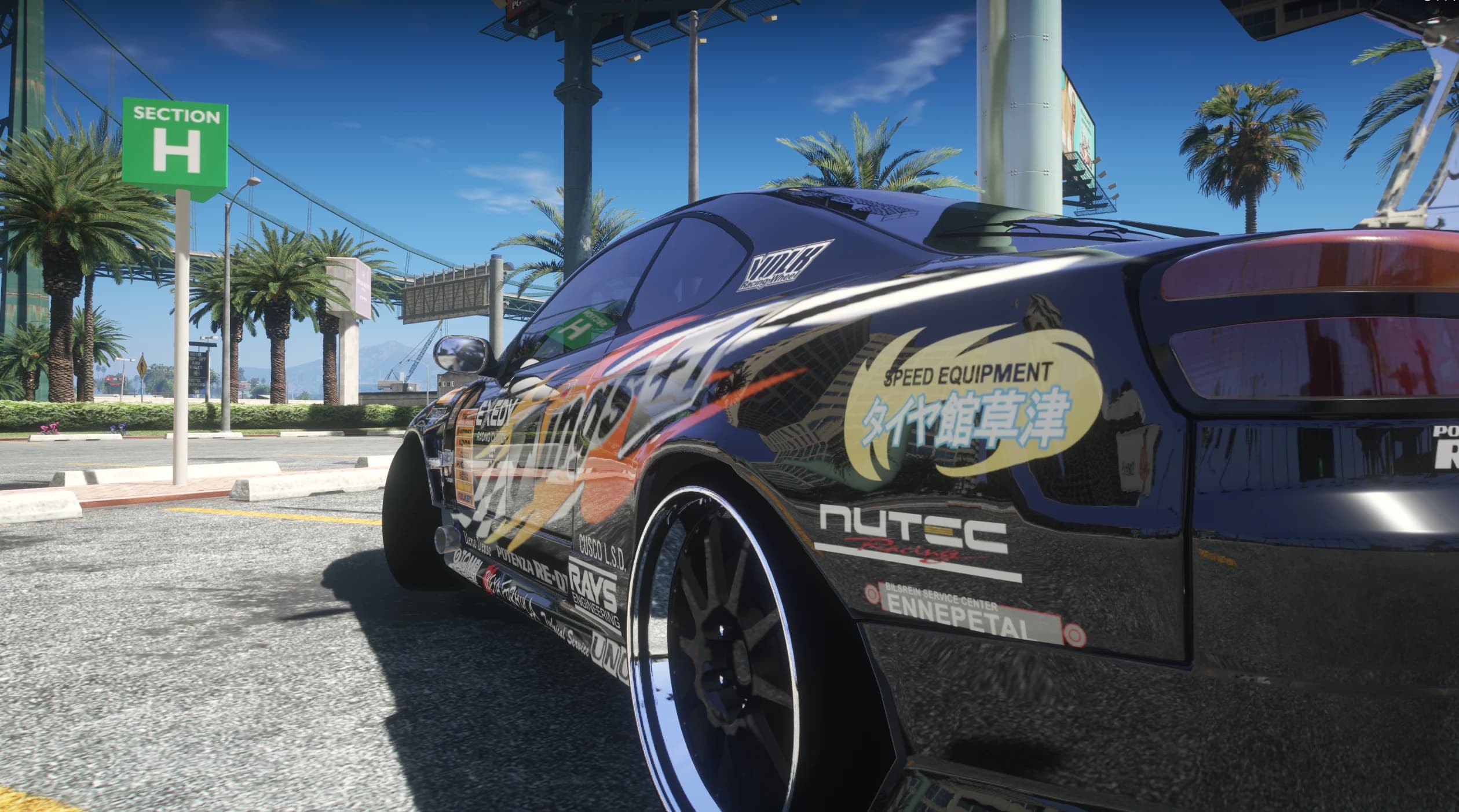 Close side view under palm trees with the Speed Equipment Japanese door decal, NUTEC and ENNEPETAL stickers and the bridge in the background