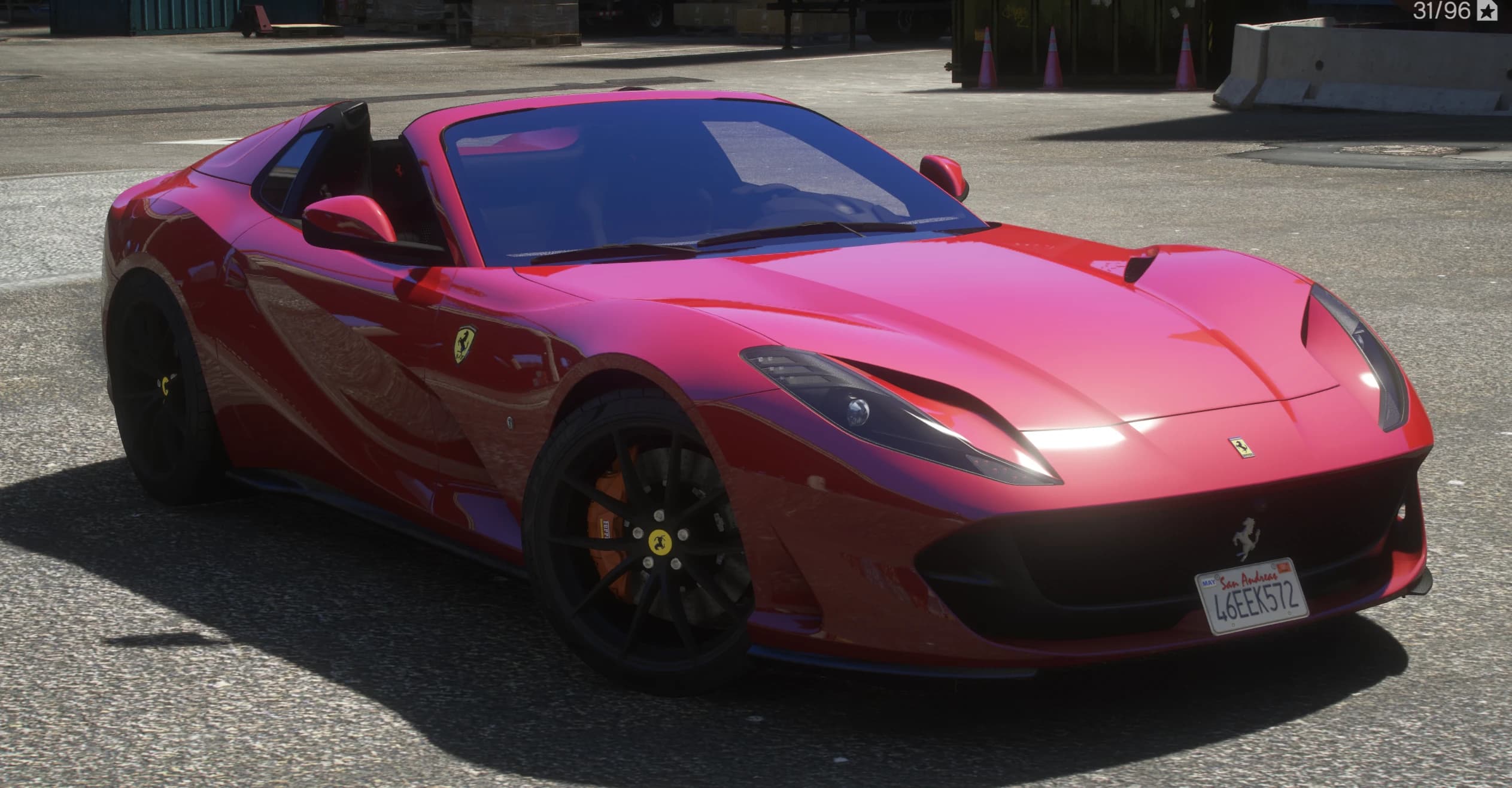 Front three quarter view of the red Ferrari 812 GTS with the roof down, black wheels, orange calipers and a San Andreas plate