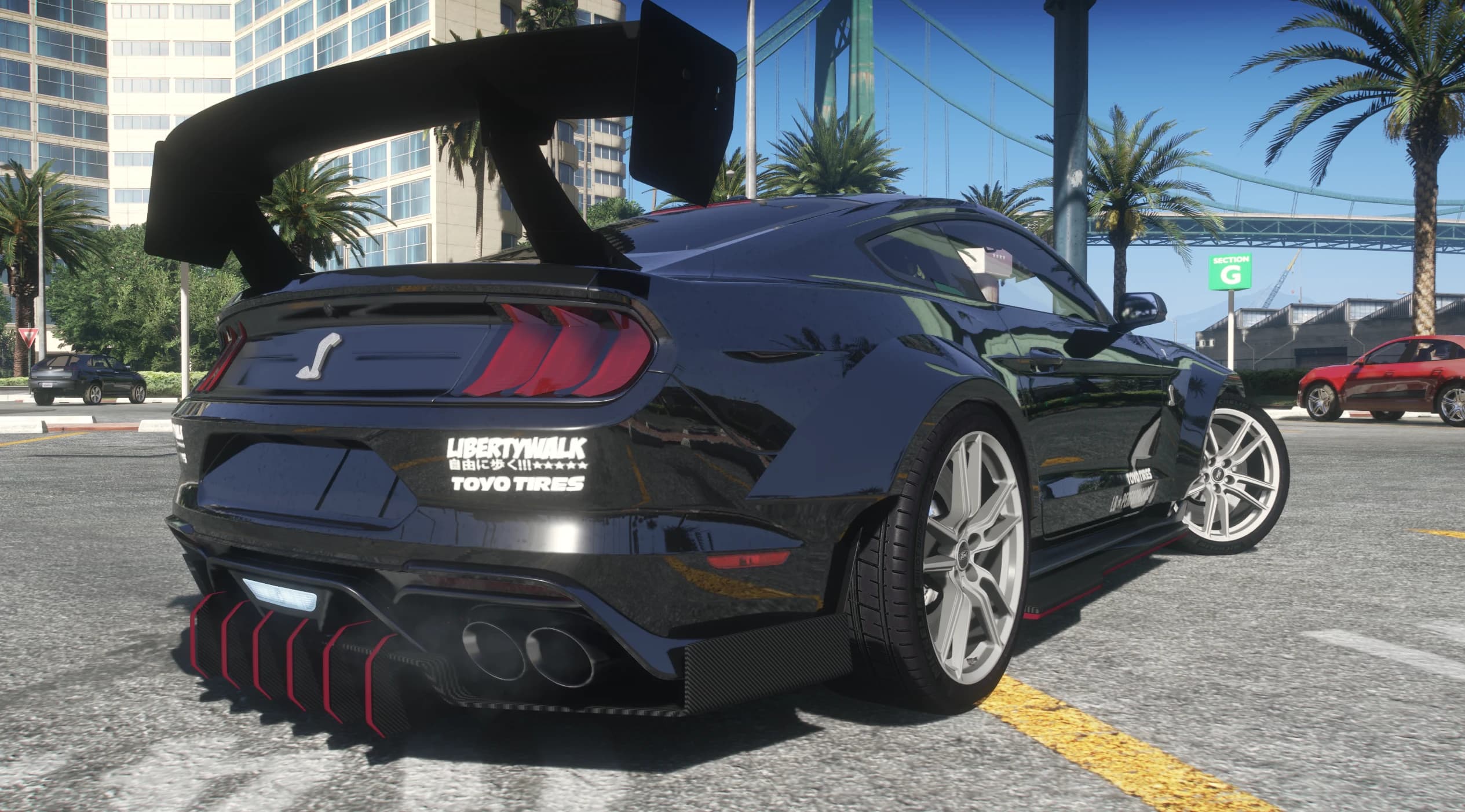 Rear three quarter view with the swan neck wing, LIBERTYWALK and TOYO TIRES decals, cobra trunk badge and red edged diffuser fins