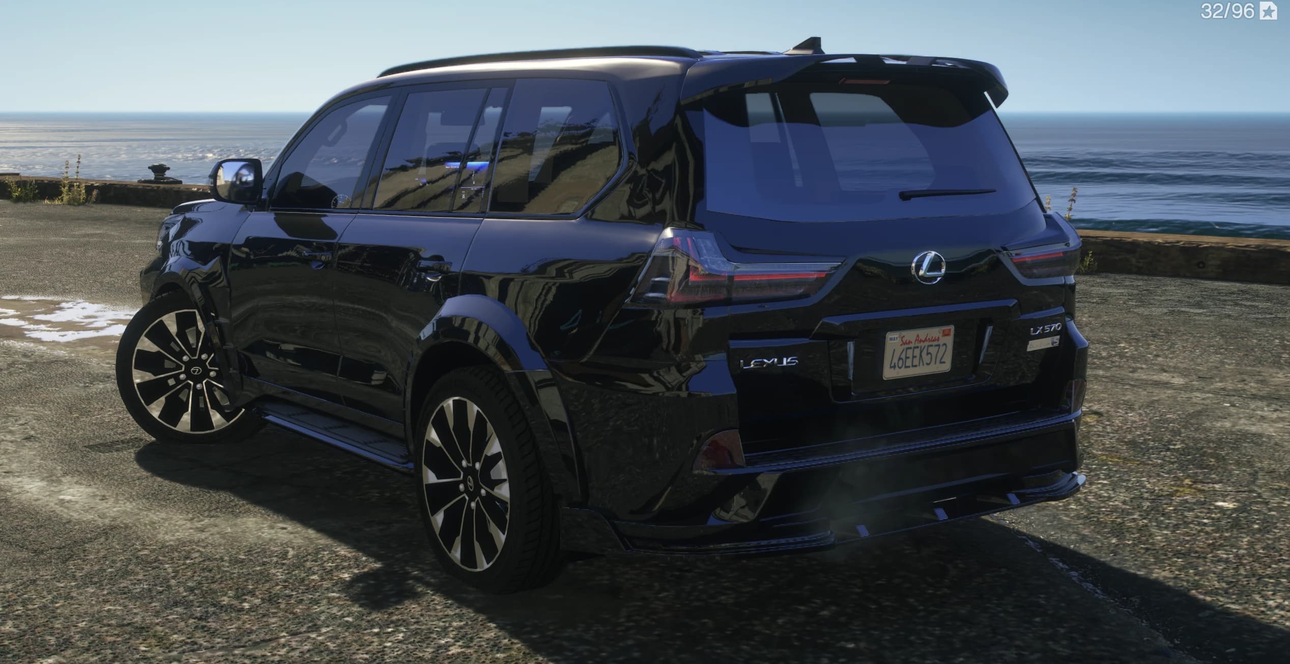 Rear three quarter view of the LX 570 by the sea showing the roof spoiler, LEXUS tailgate lettering and diffuser fins