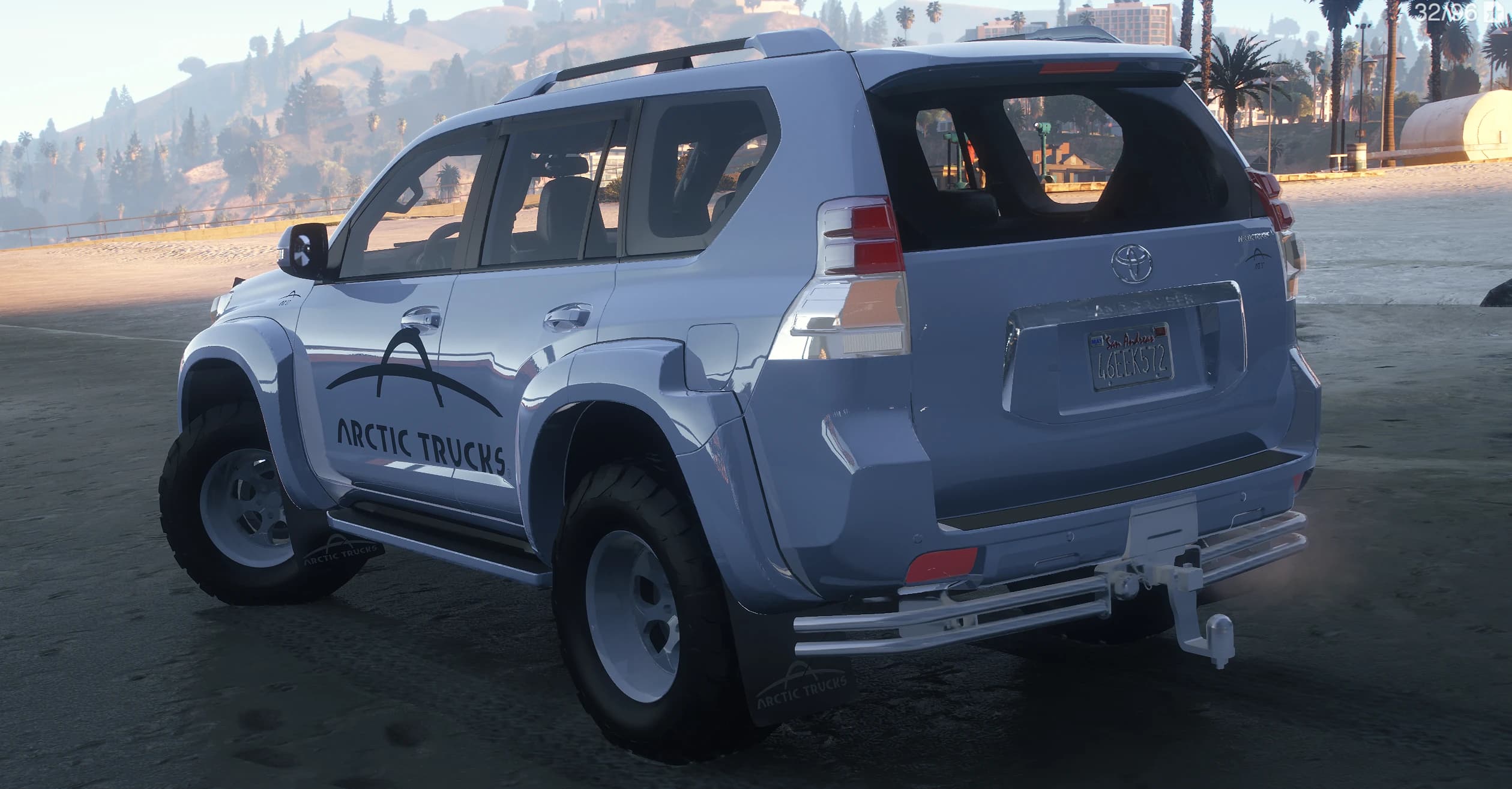 Rear three quarter of the Prado showing the roof rails, rear tow bar, chunky off-road tyres and the Land Cruiser badge