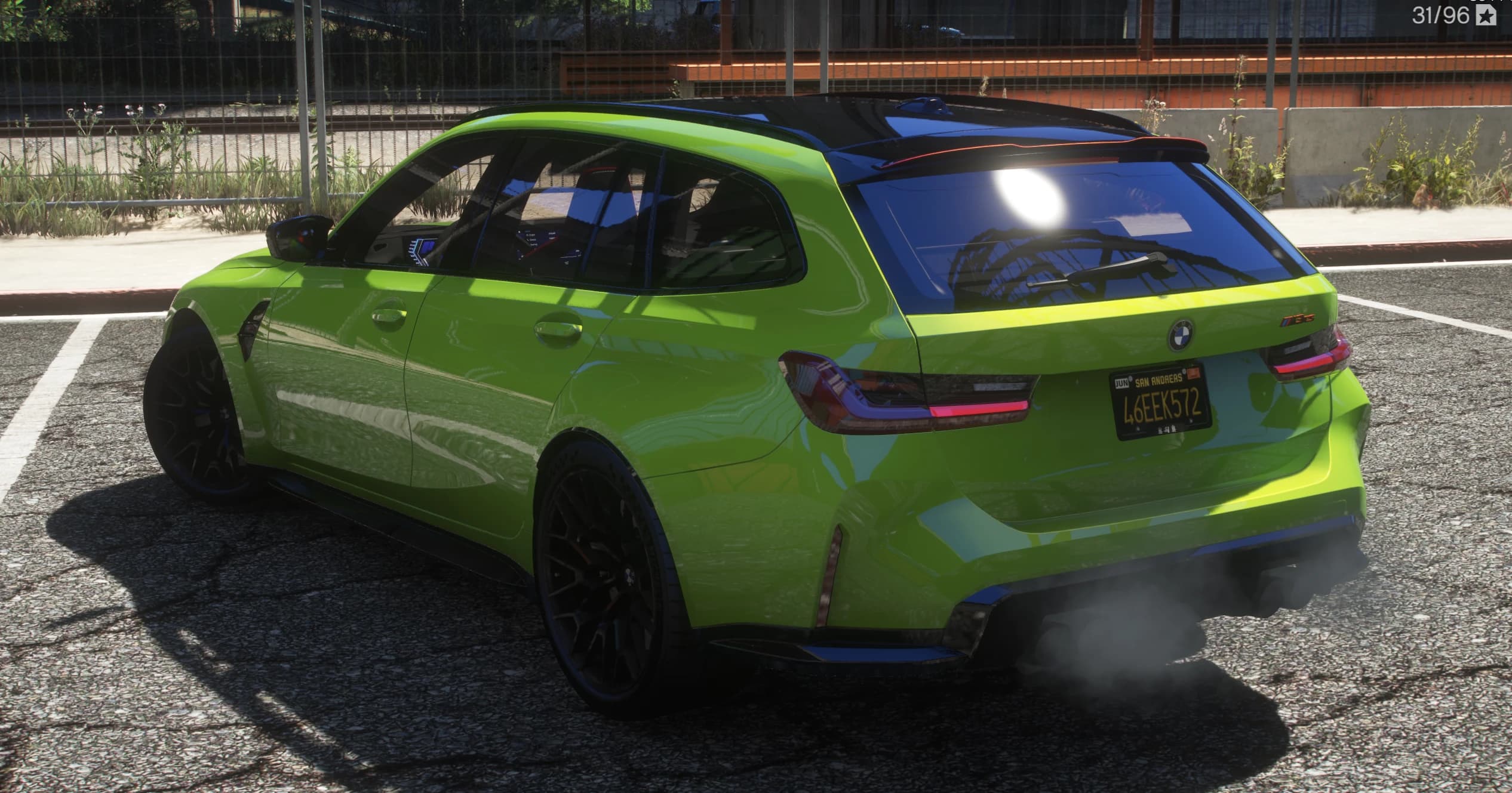 Rear three quarter view of the green estate with smoked taillights, black roof and the red trimmed tailgate spoiler