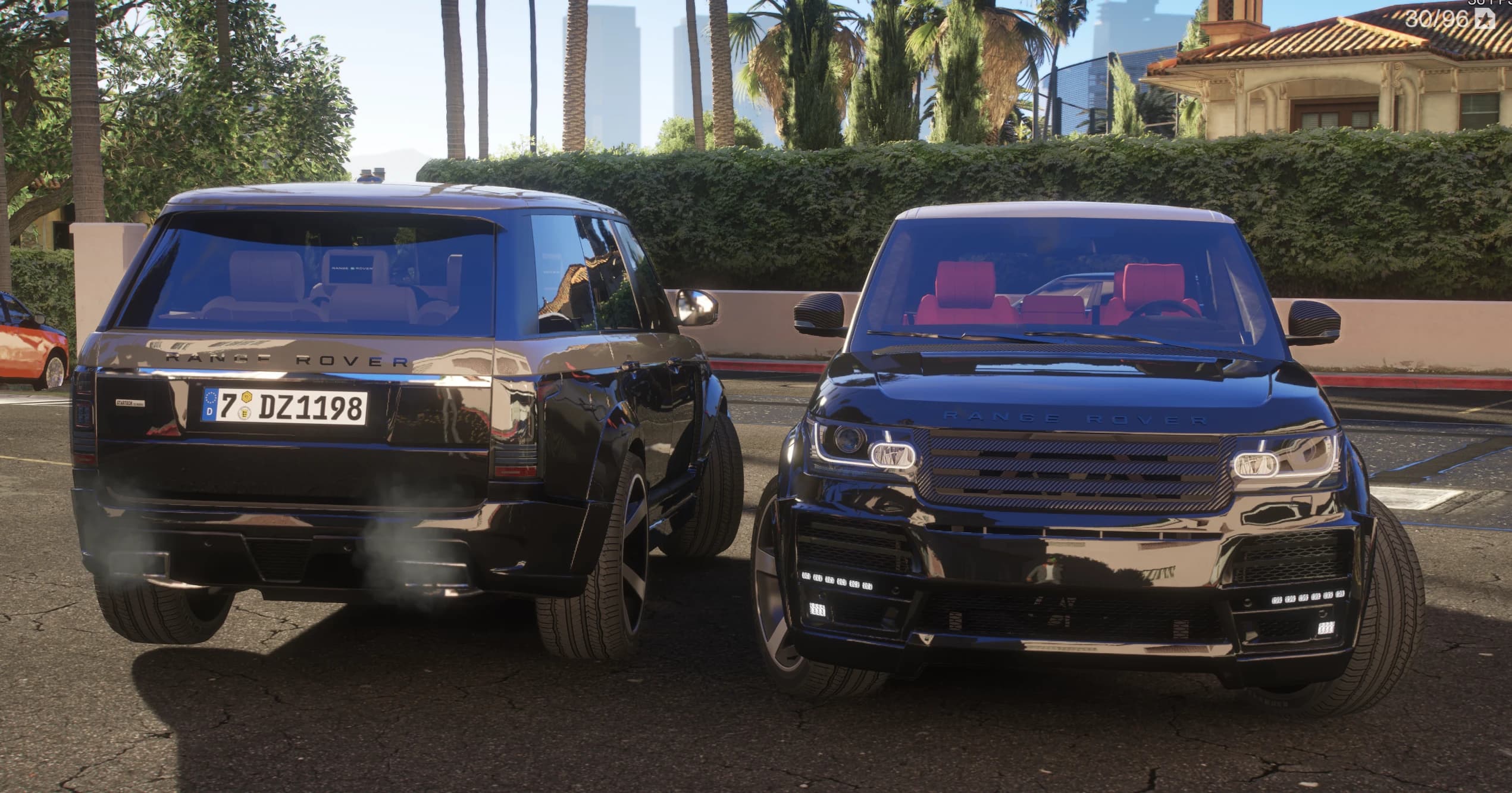 The two Range Rovers face to face under the palms, one showing the European plate and the other its red leather interior