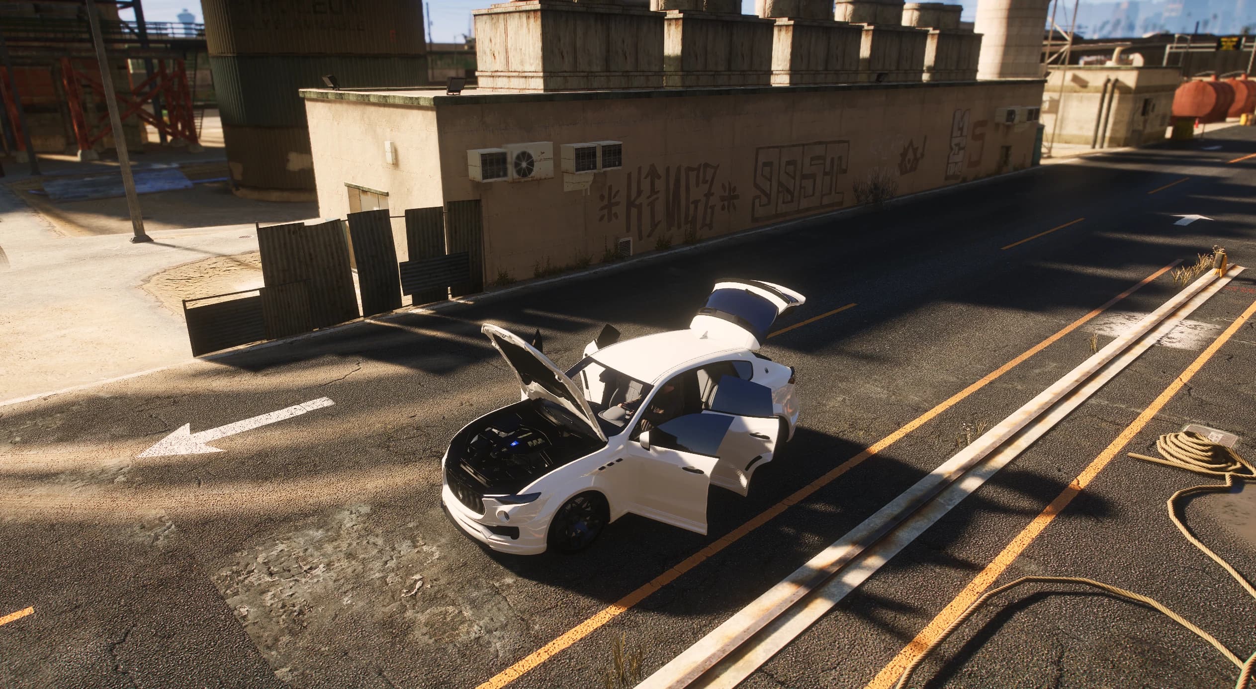 Elevated shot of the white Levante on a dock road with the hood, all four doors and the tailgate open, showing the modelled engine bay and the pale leather cabin