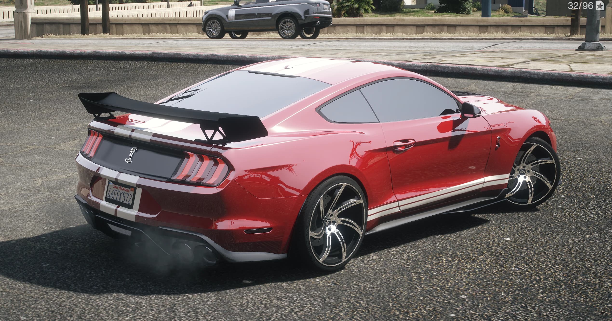 Rear three quarter view of the GT500 Custom with the tall black wing, cobra badge on the tail panel and quad exhaust