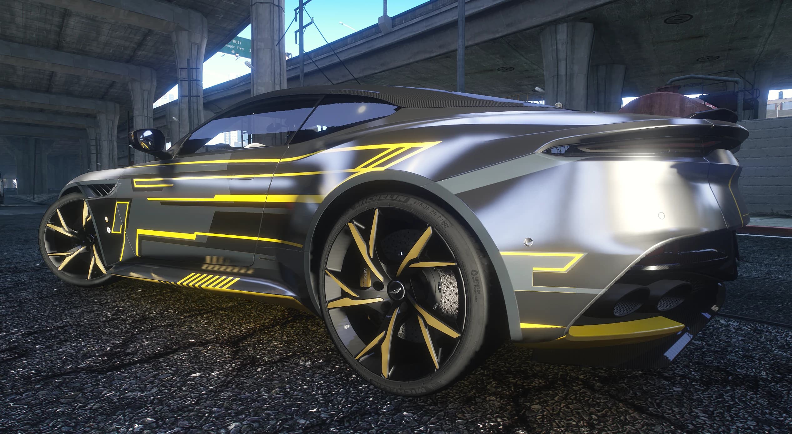 Side view of the gray DBS Superleggera with the yellow line livery and gold accented wheels