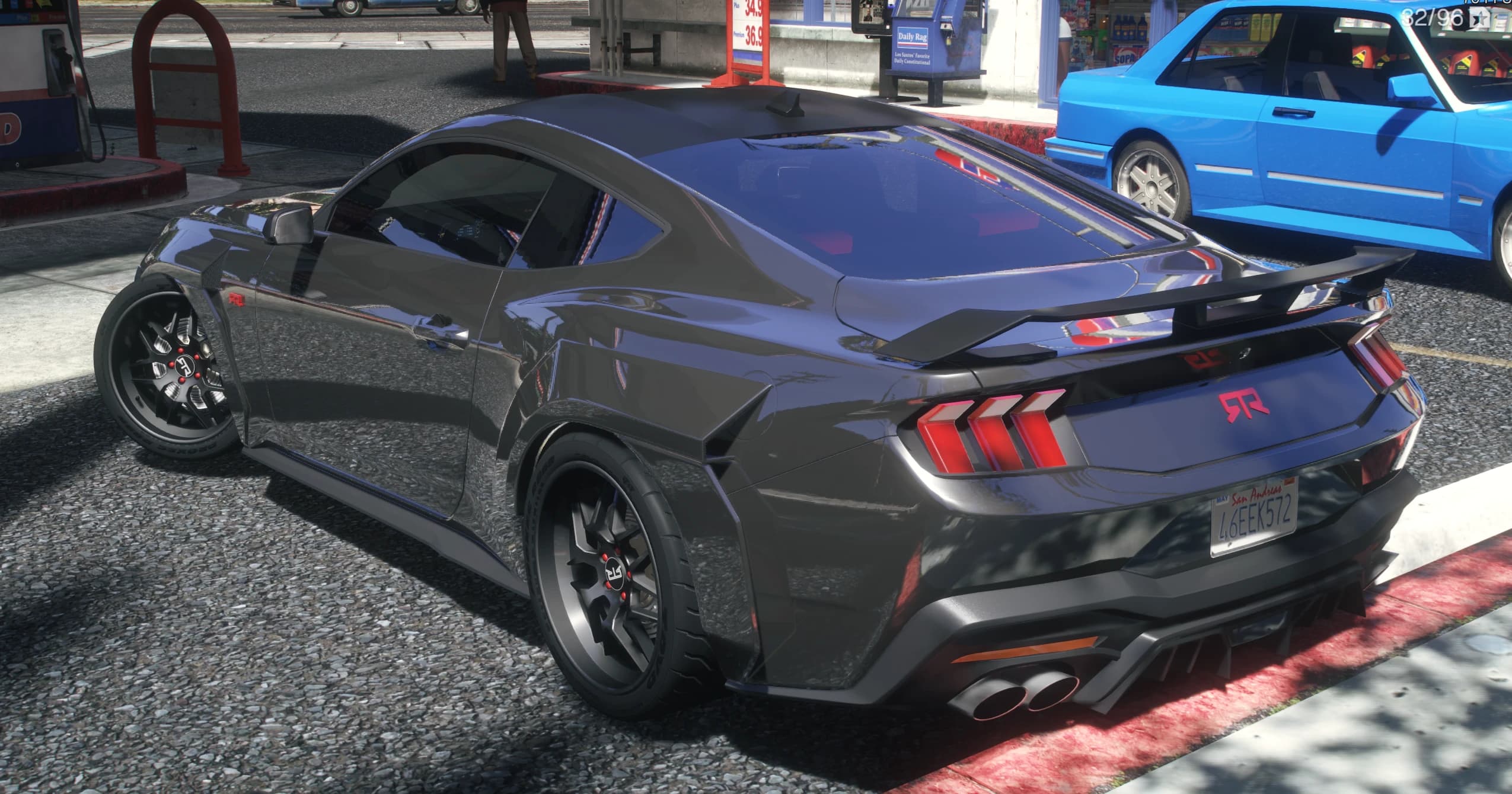 Rear three quarter view of the Mustang RTR at a gas station with the spoiler, chevron taillights and RTR lettering