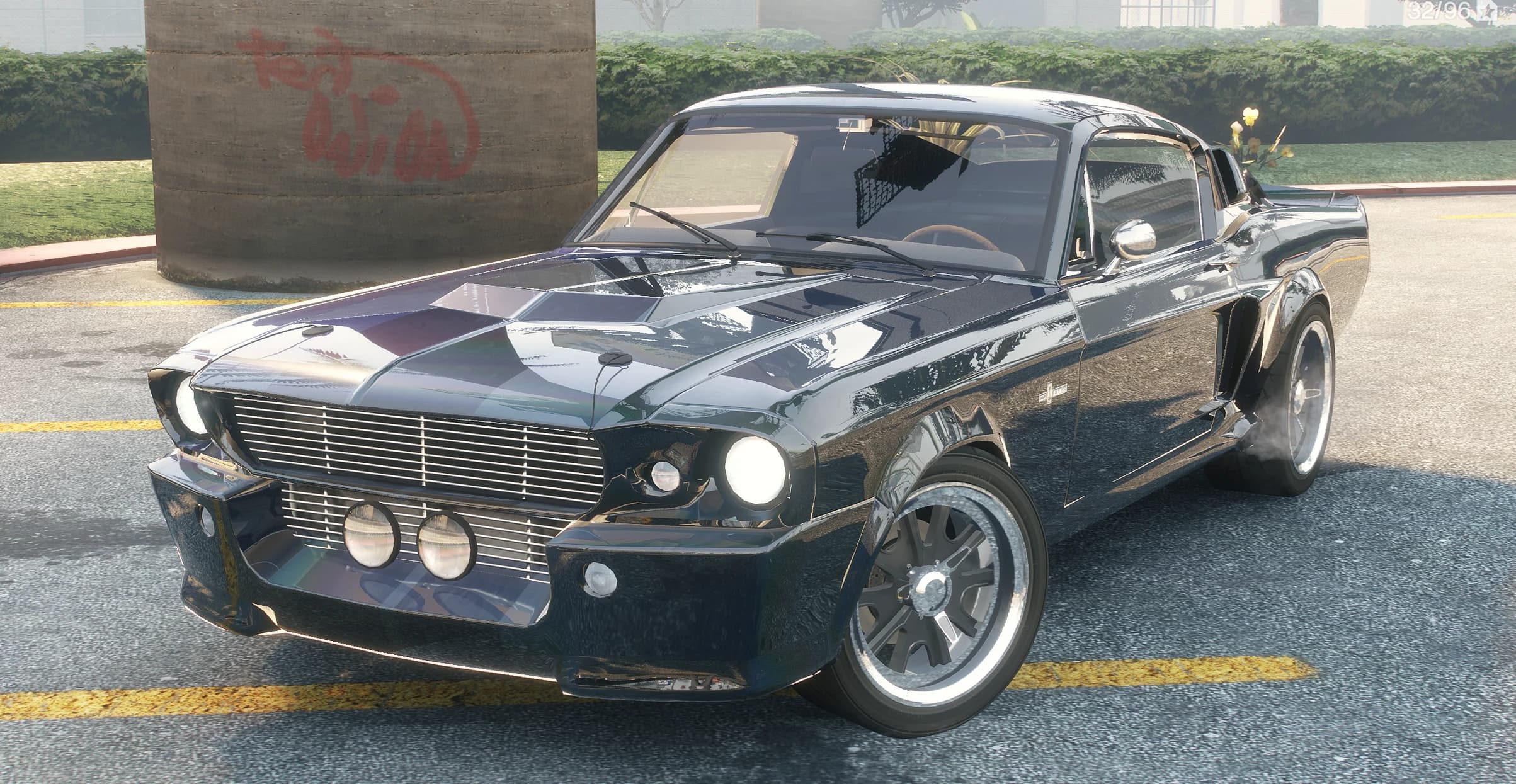 Dark navy Eleanor with hood scoops and chrome mirrors parked by a graffiti covered pillar