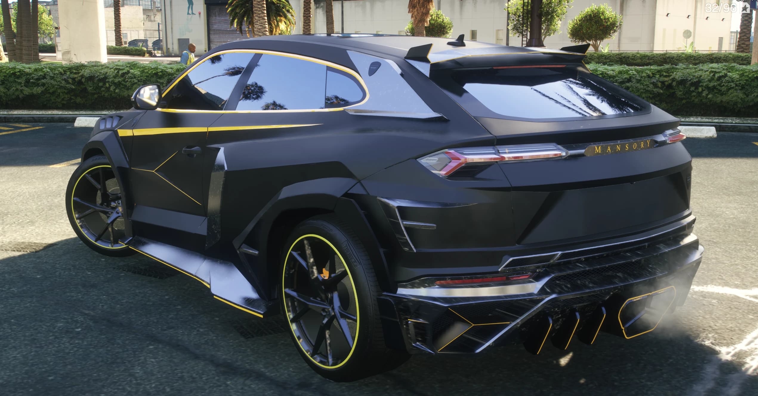 Rear three quarter view of the coupe with the MANSORY tailgate lettering, roof spoiler and yellow outlined diffuser