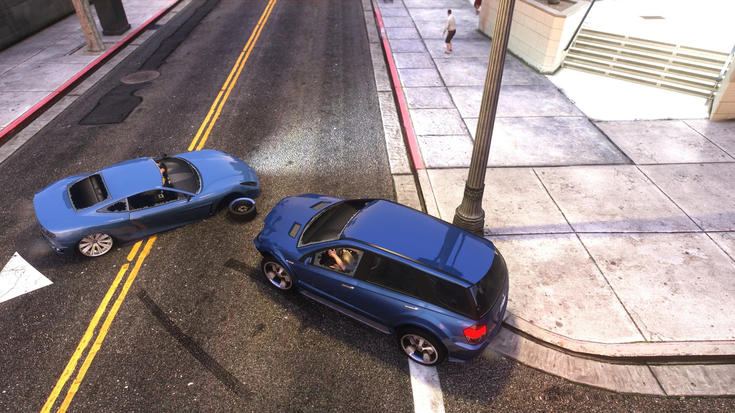A sedan and an SUV after a side collision, with a wheel torn clean off the car lying in the middle of the road