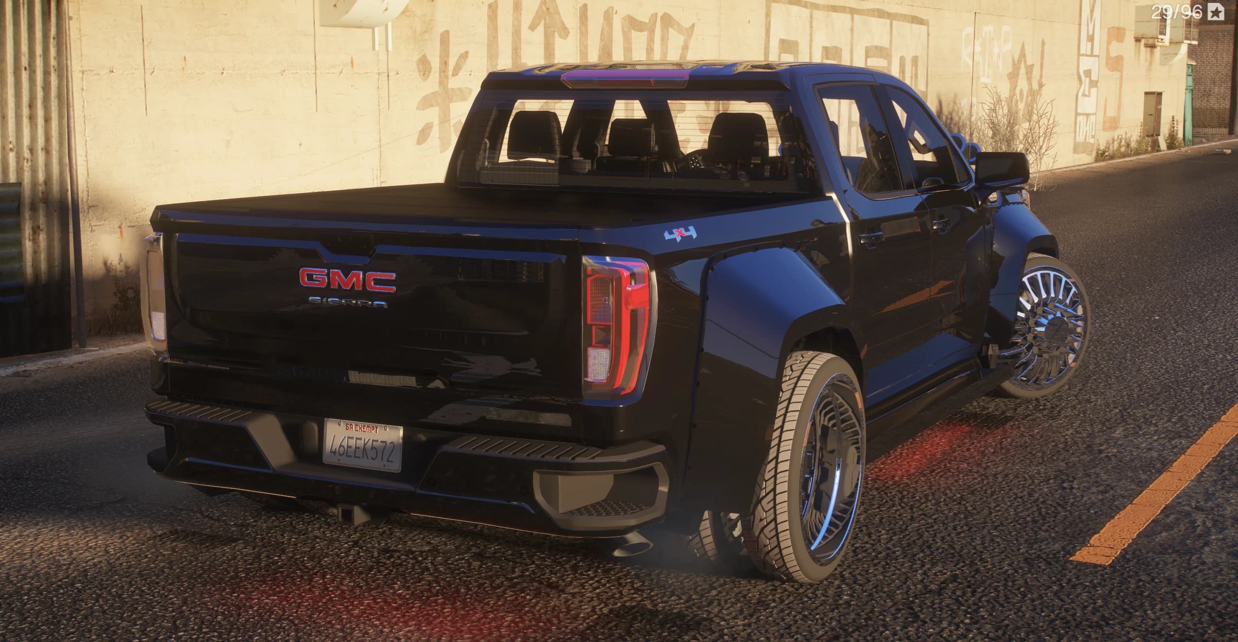Rear three-quarter of the Sierra with the GMC Sierra tailgate badge, the 4x4 lettering, a tonneau cover and chrome dually wheels