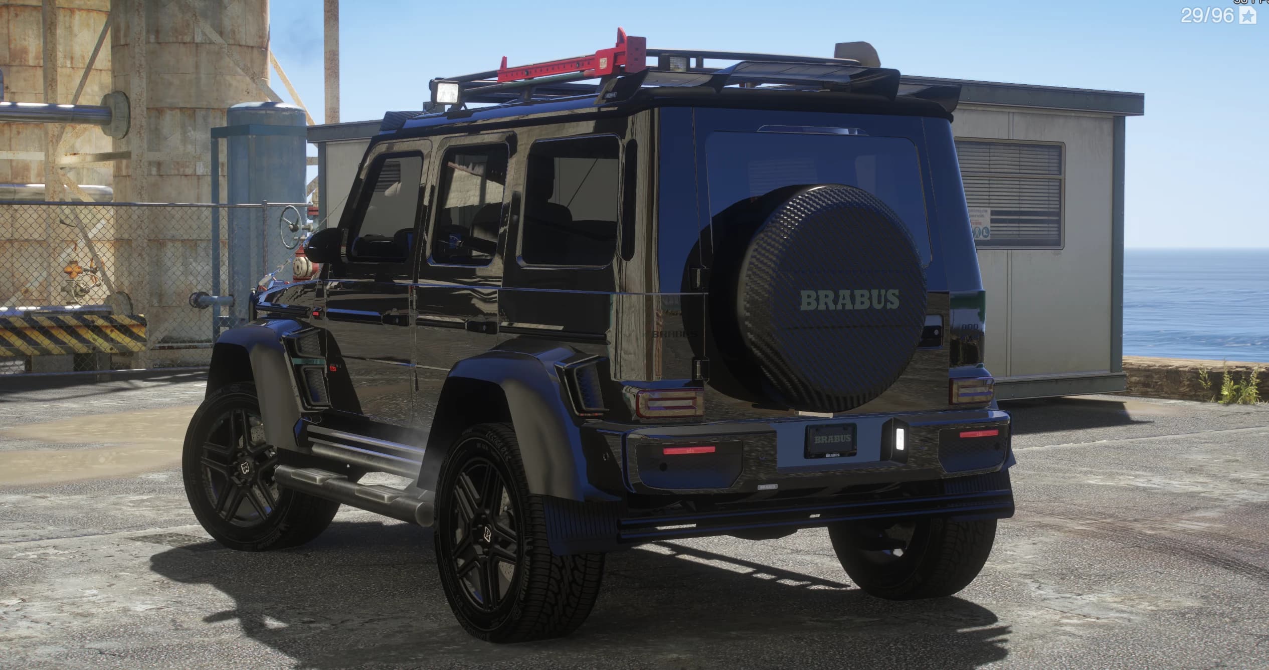 Rear three-quarter of the G800 at a dock, showing the tailgate spare-wheel cover reading BRABUS and the carbon roof rack with red recovery tracks