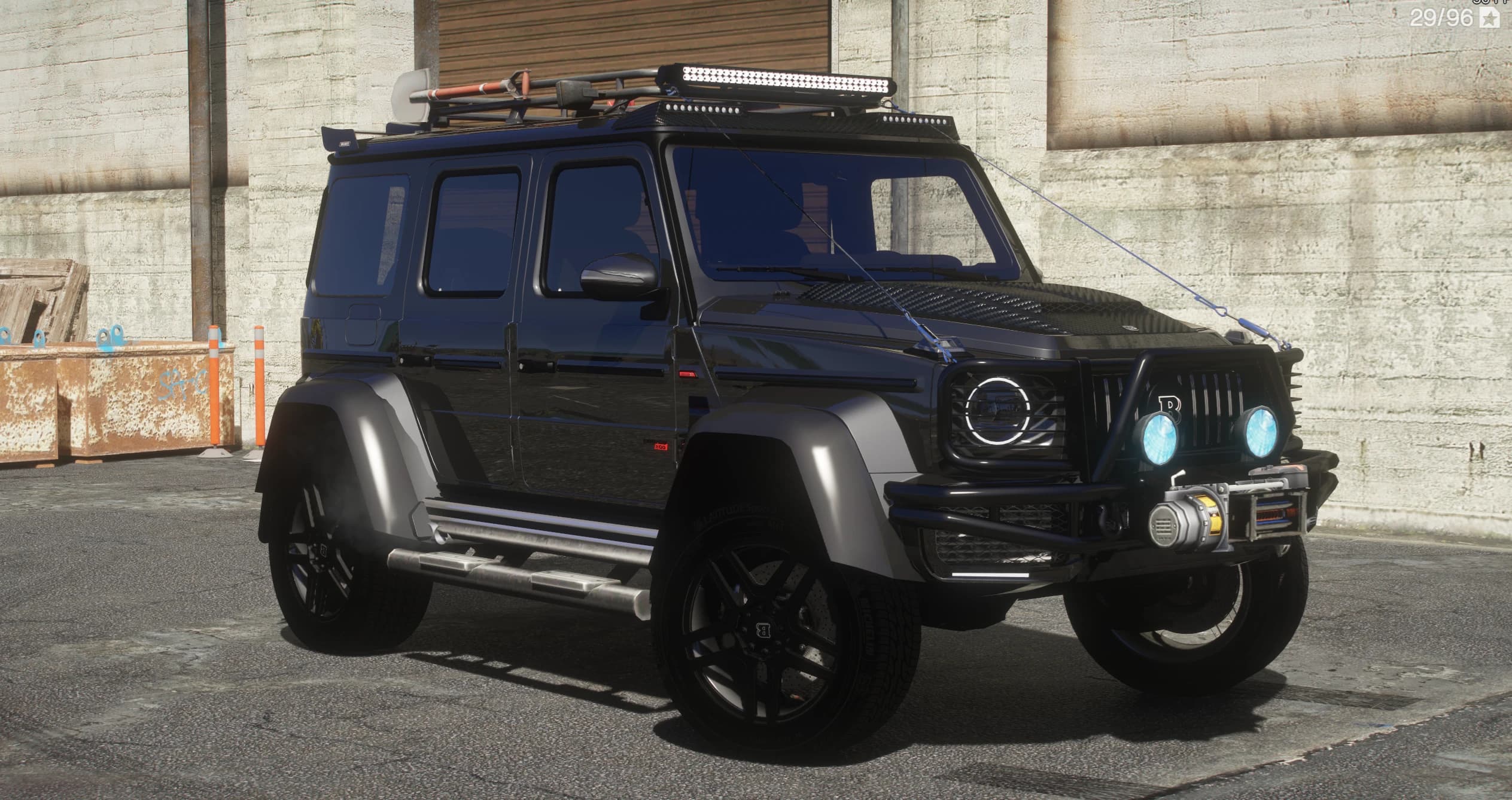 The same G800 in an off-road build with a tubular bull bar, working winch, blue-lit auxiliary spotlights and a roof rack loaded with a shovel and recovery tracks