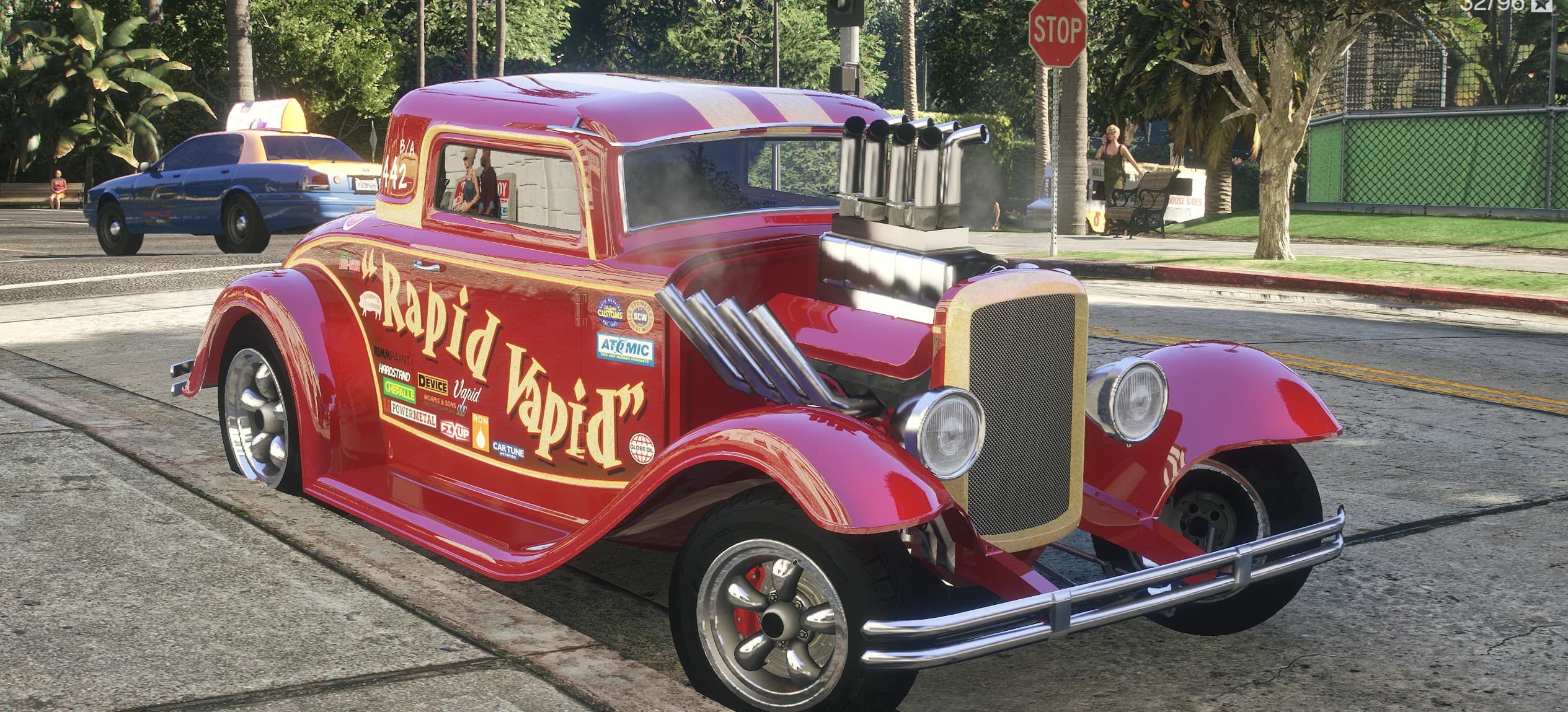 Front view of the red XHustler hot rod with the Rapid Vapid livery and a supercharged engine with chrome stacks