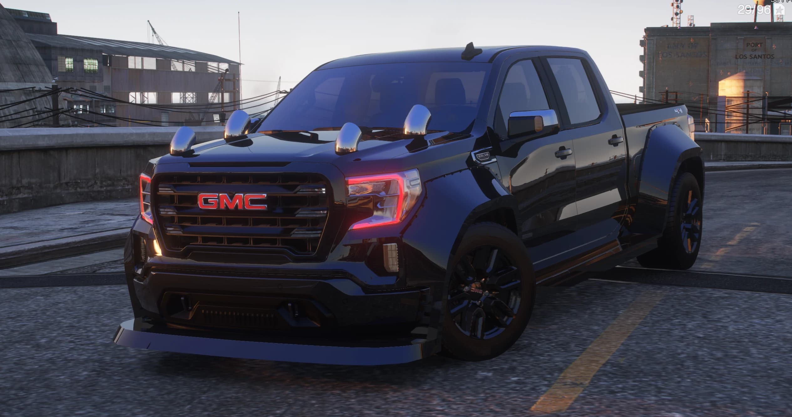 Black 2021 GMC Sierra widebody crew-cab pickup with red GMC grille badge, chrome tow mirrors, front splitter and black wheels, at the Port of Los Santos
