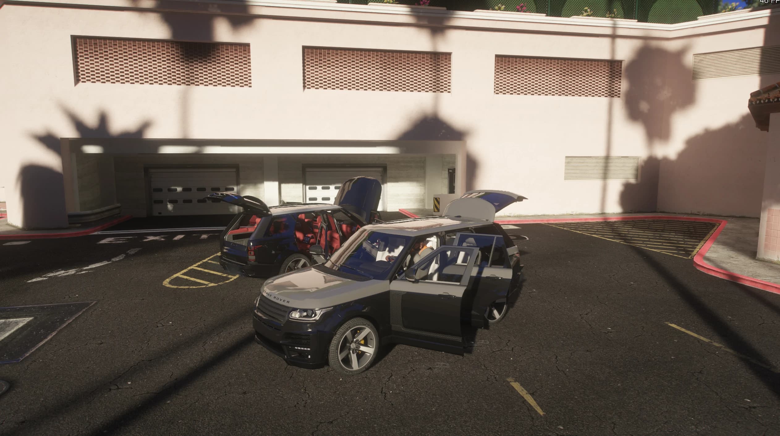Both SUVs with doors and tailgates open outside a parking garage, showing the light and the red interiors