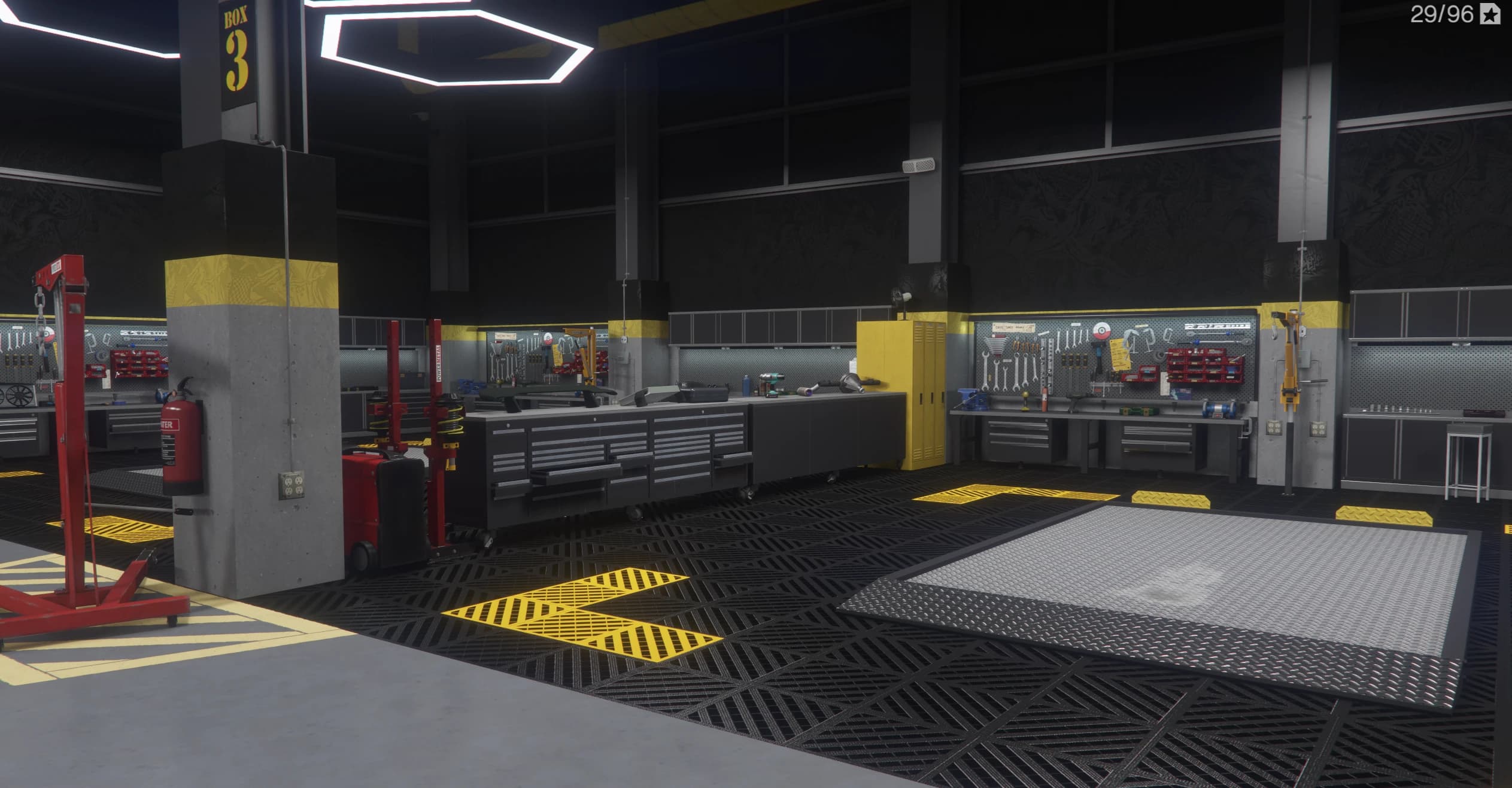 Work bay number three with tool walls, rolling tool chests, an engine crane and a vehicle lift plate