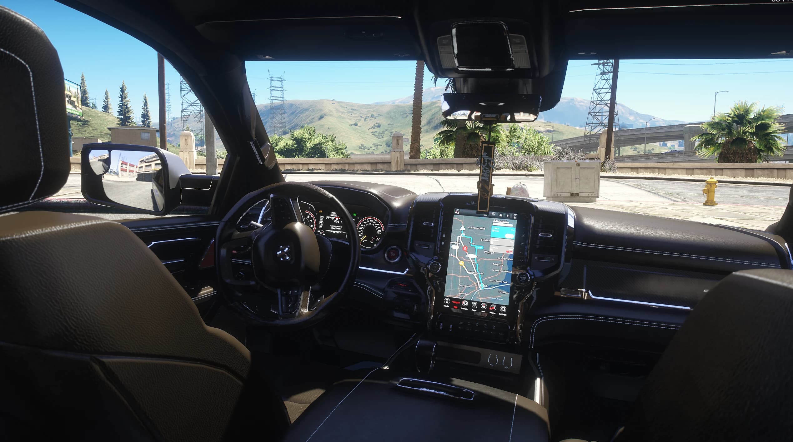 Leather interior with the portrait touchscreen showing navigation, digital cluster and the RAM badge on the steering wheel