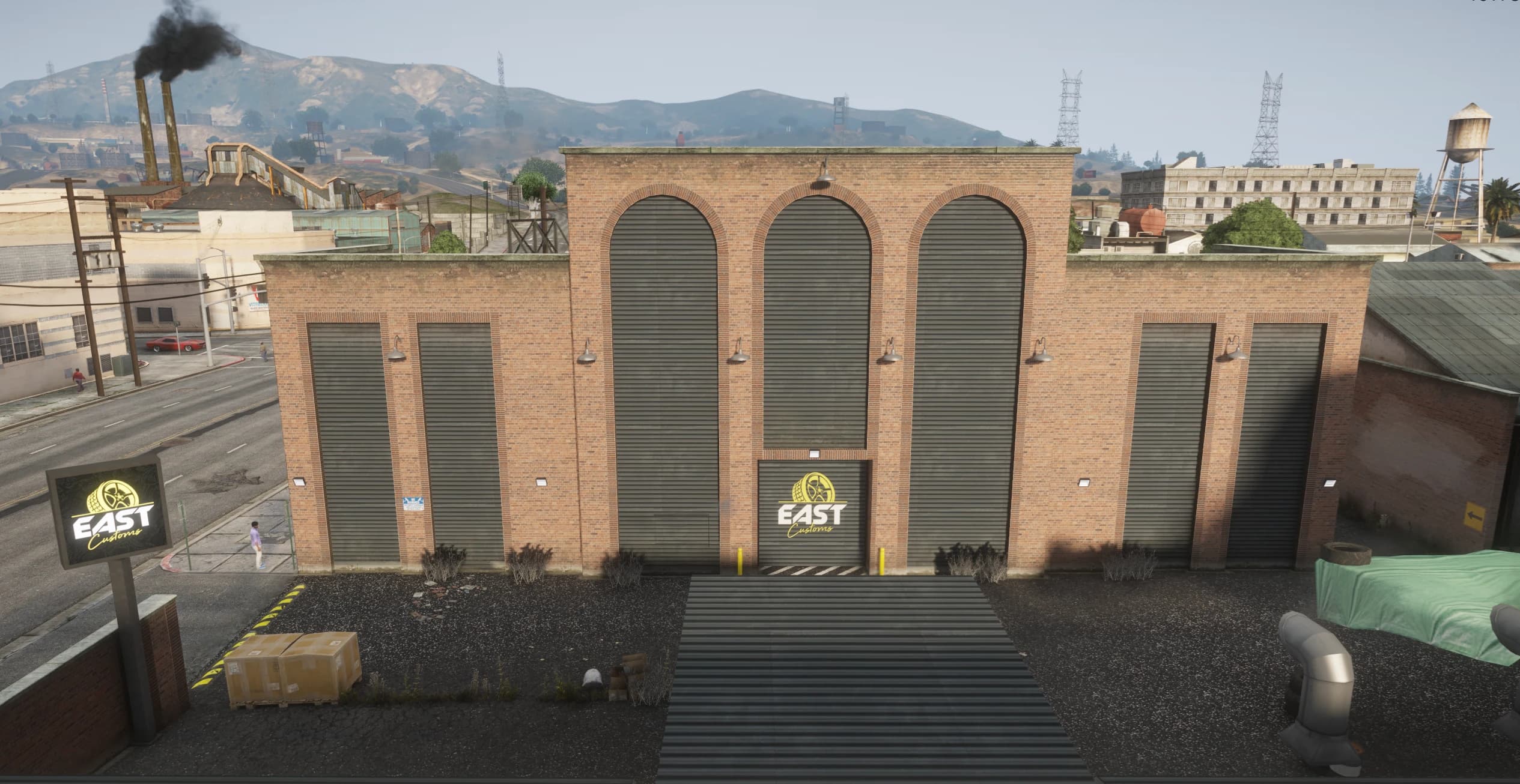Street facade of the brick EAST Customs building with its arched roller doors and logo signs