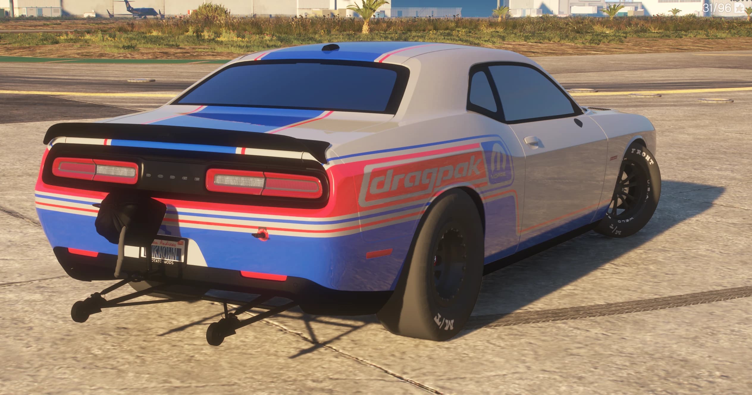 Rear three quarter view showing the wheelie bars, the parachute pack, the dragpak and Mopar quarter panel livery and the DODGE taillight bar