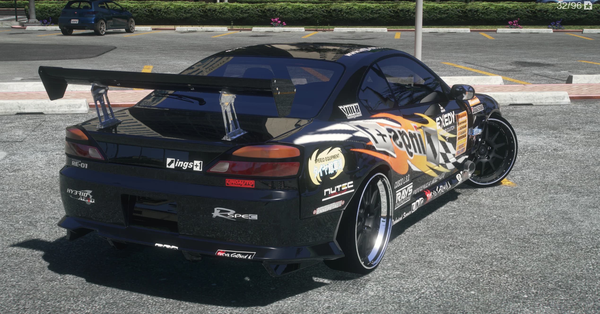 Rear three quarter view showing the GT wing on billet stands, amber taillights, diffuser and deep dish wheels with polished lips