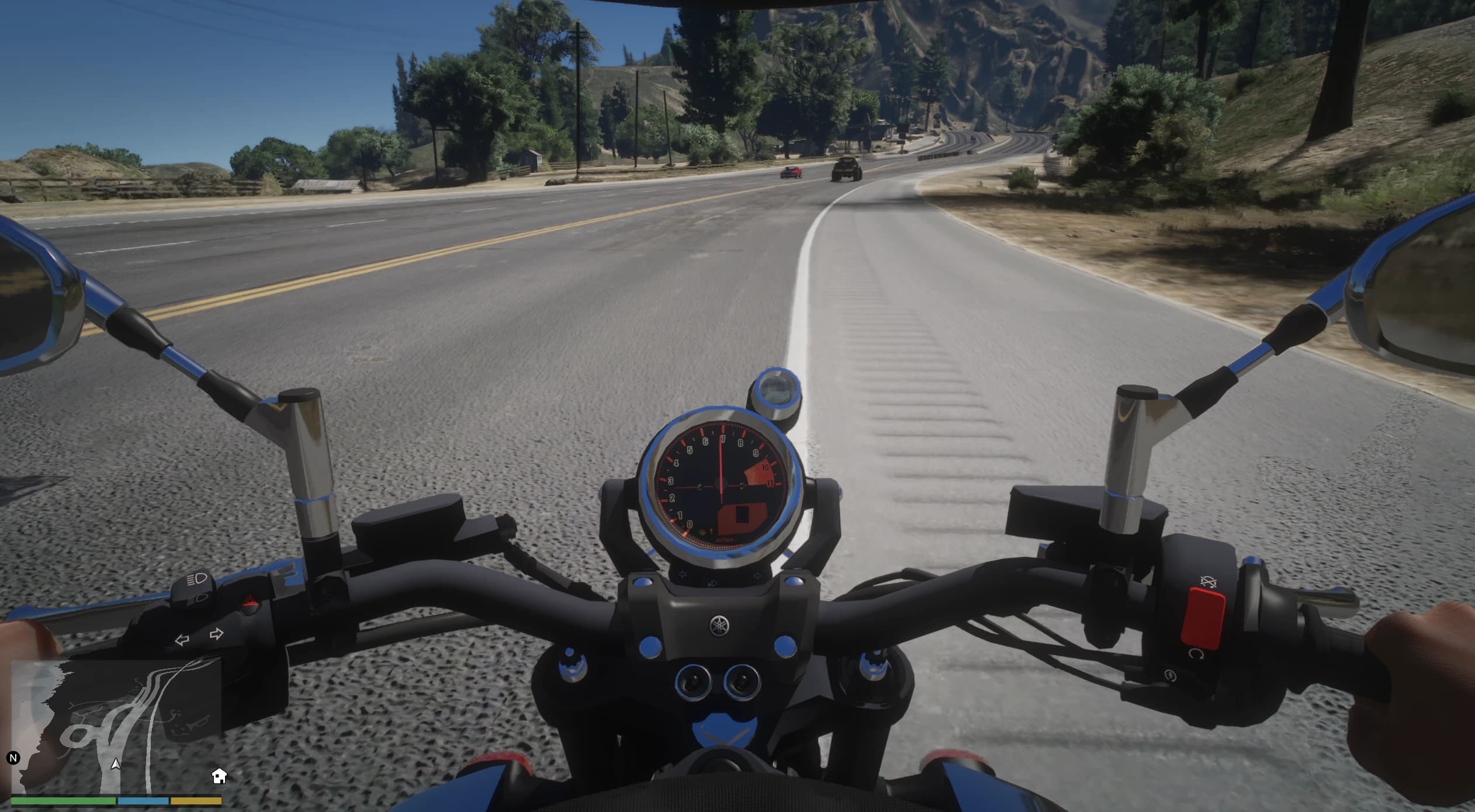 First person riding view on a country highway with the chrome ringed round tachometer between the mirrors