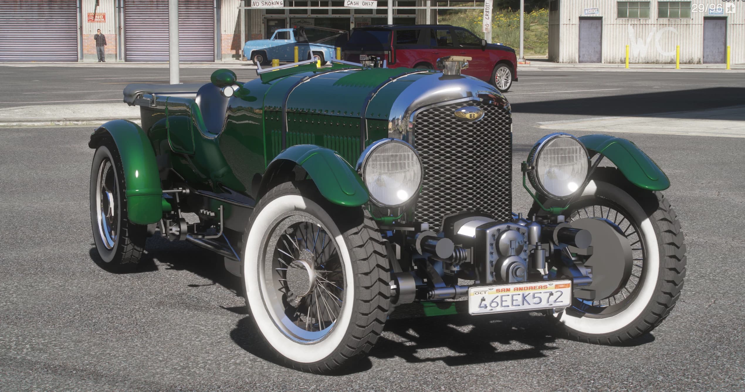 British Racing Green 1930 Bentley Speed Six Le Mans Tourer, front three-quarter view with the exposed supercharged engine, the winged Bentley badge on the mesh grille and whitewall spoke wheels