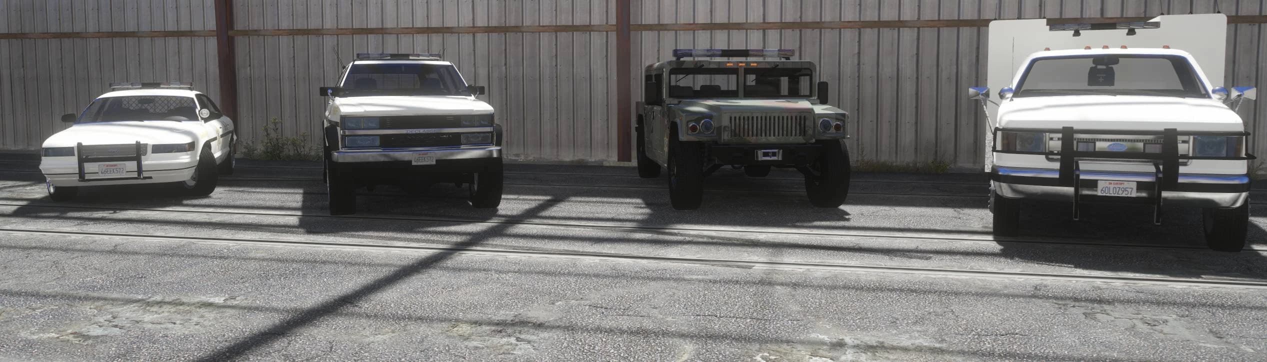 The front row of four sheriff vehicles — a cruiser, an SUV, a camo Humvee and a rescue truck — lined up in the retro Blaine County Sheriff livery