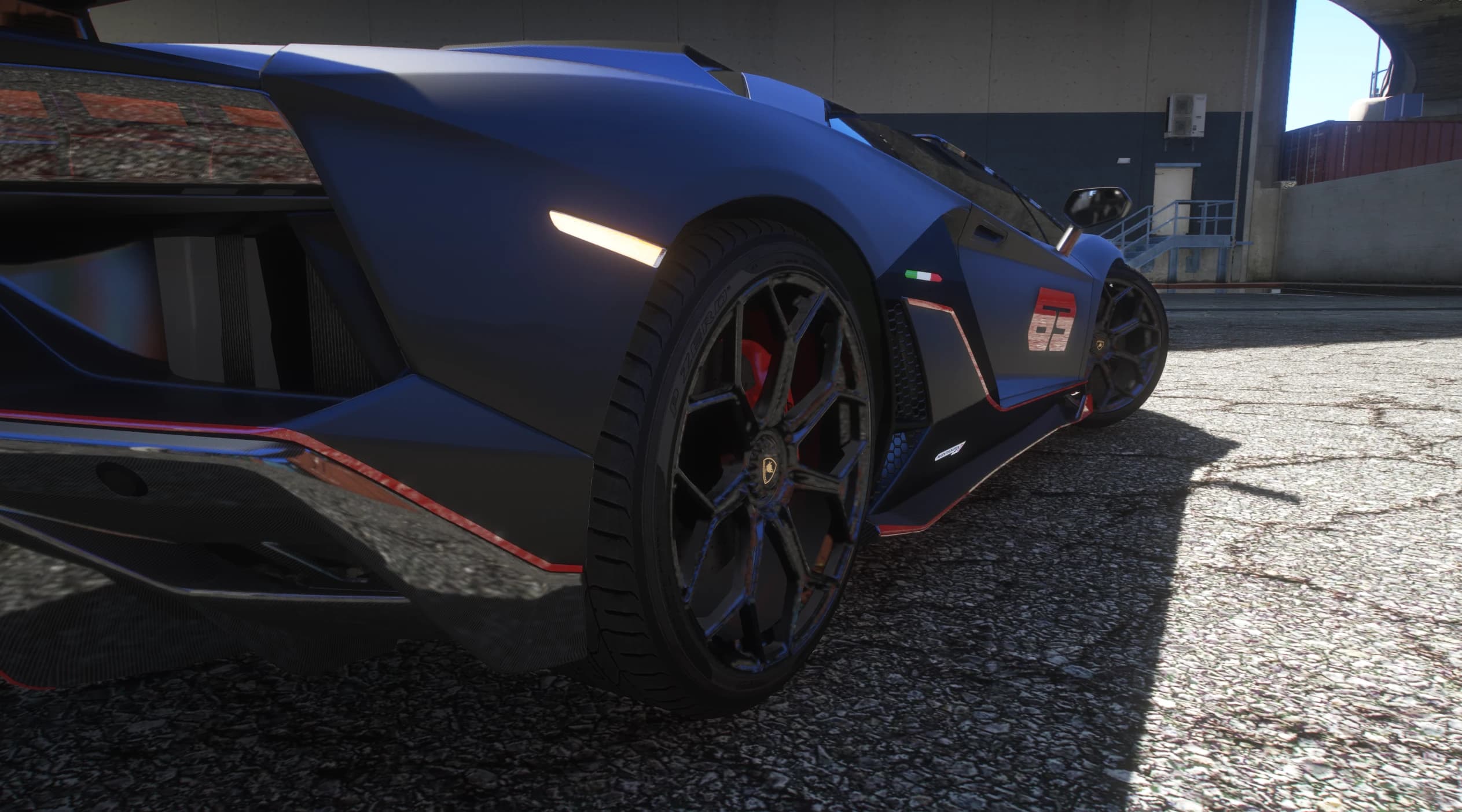 Low rear detail of the carbon diffuser edged in red, the red caliper and the Italian flag stripe above the side intake