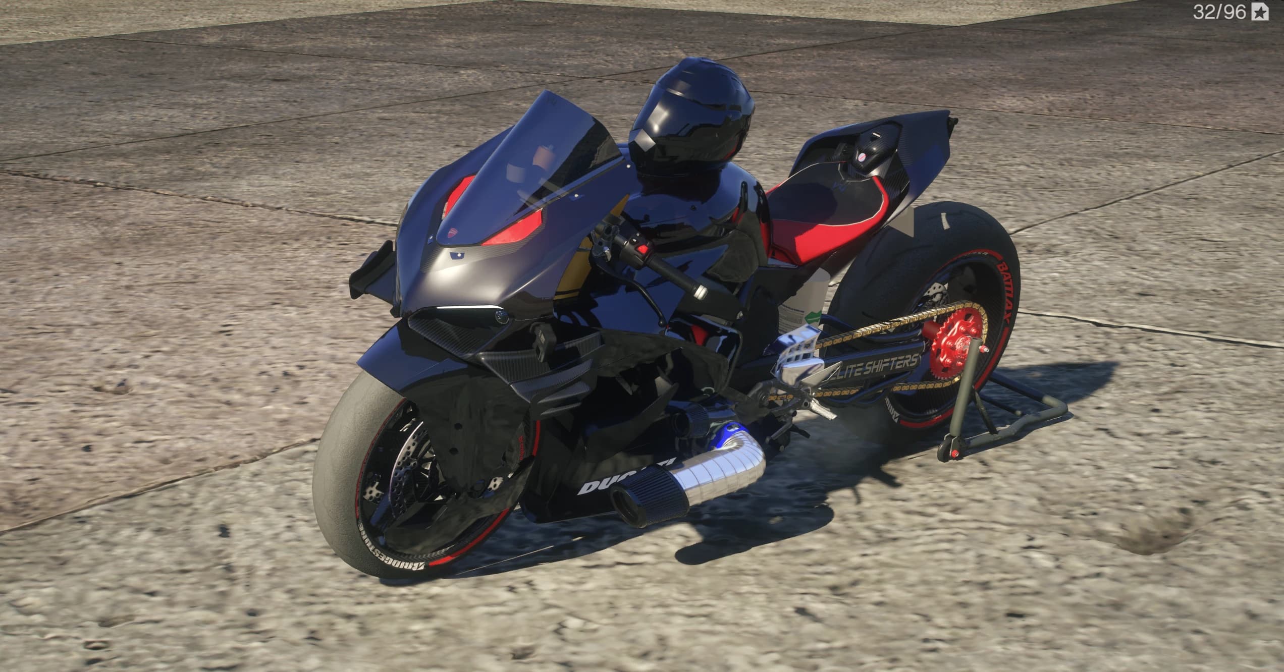 Front three quarter view of the black Ducati V4 drag bike with red nose accents, stretched Elite Shifters swingarm, gold chain and chrome charge pipe