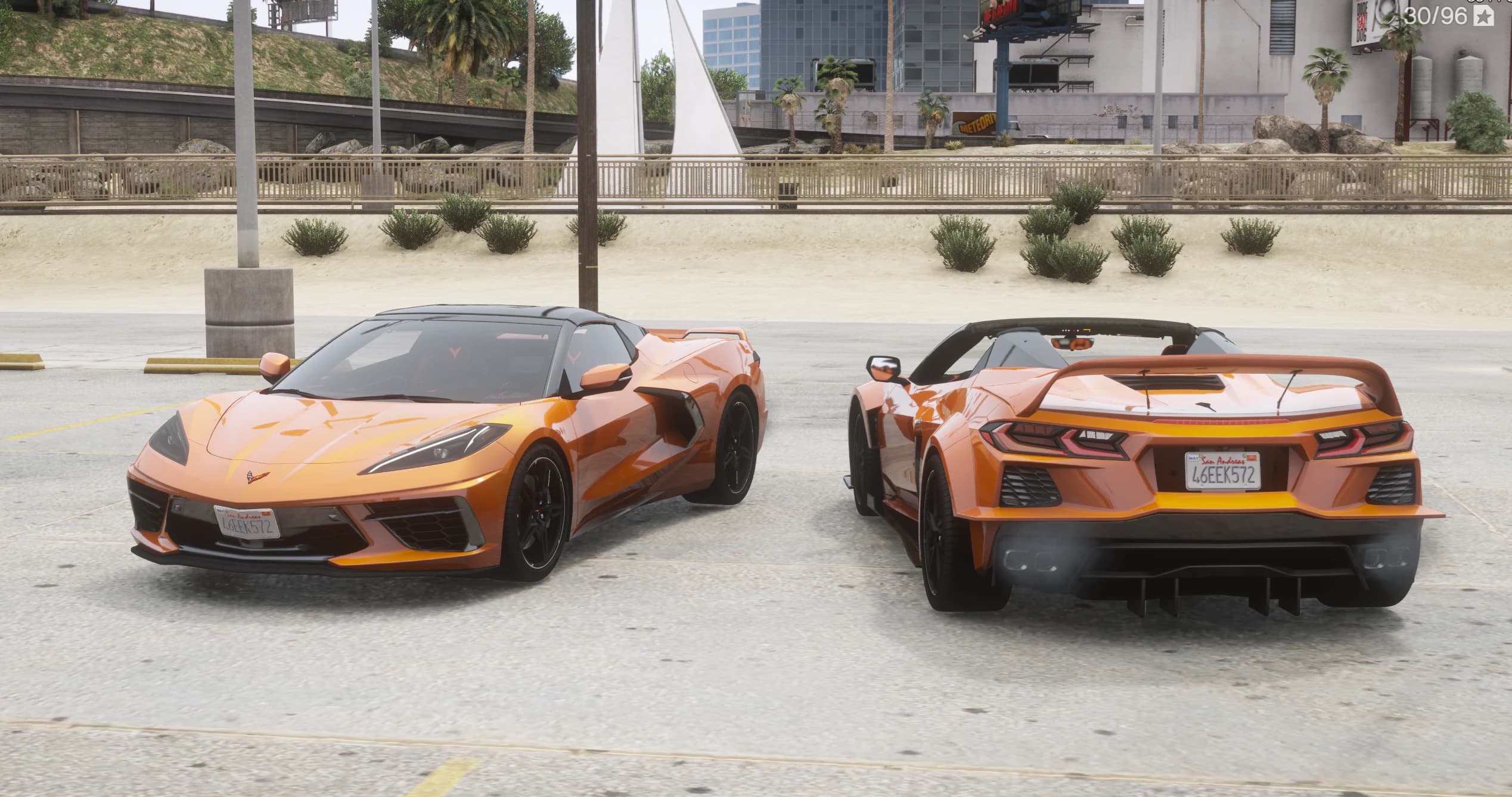 The two versions side by side by the beach: the standard c8c facing the camera with the roof up and the open-top widetrack c8cw behind, showing its tall rear wing