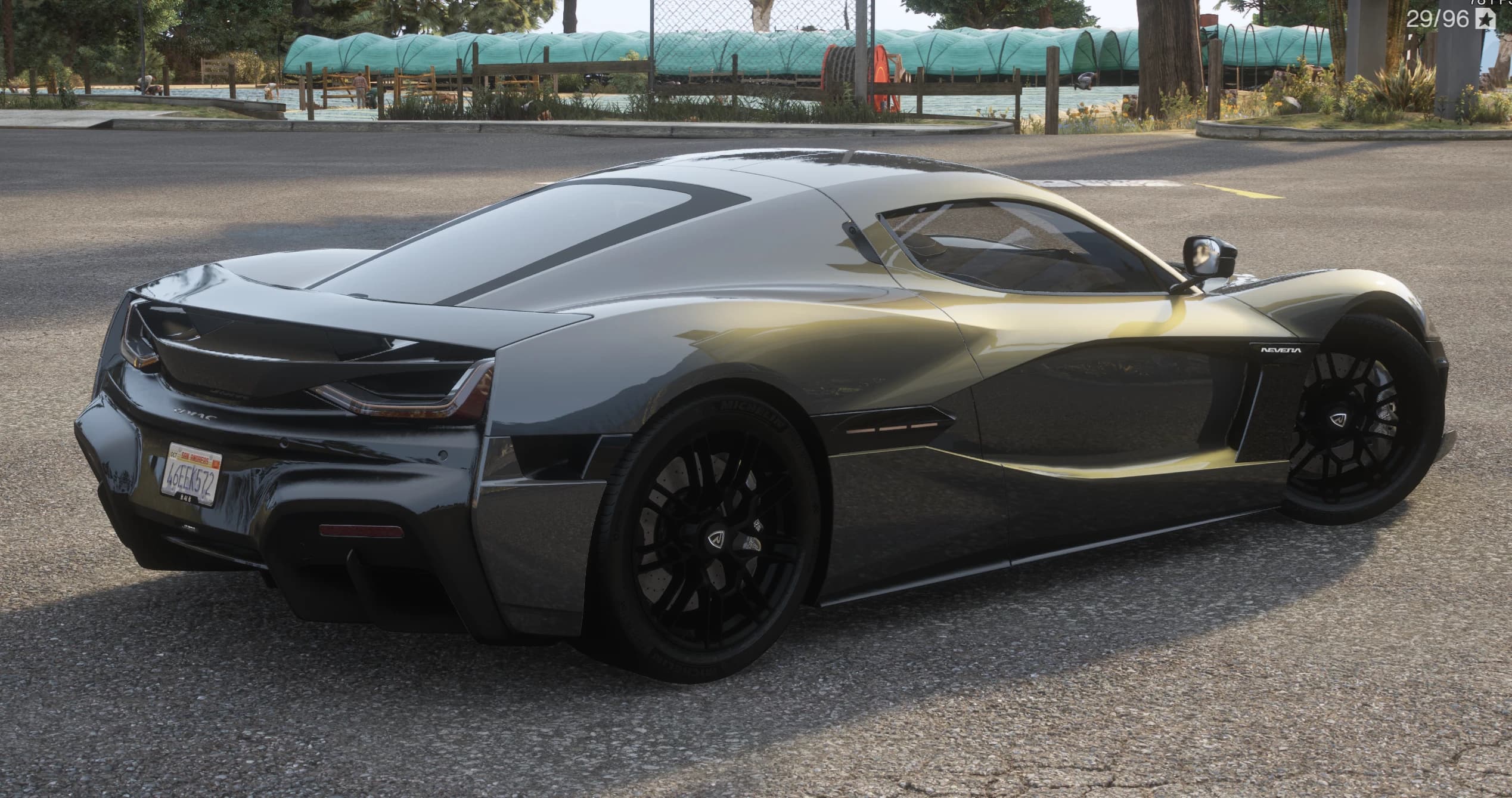 Rear three-quarter of the grey Rimac Nevera showing the full-width light bar, the NEVERA side lettering and the RIMAC tail badge