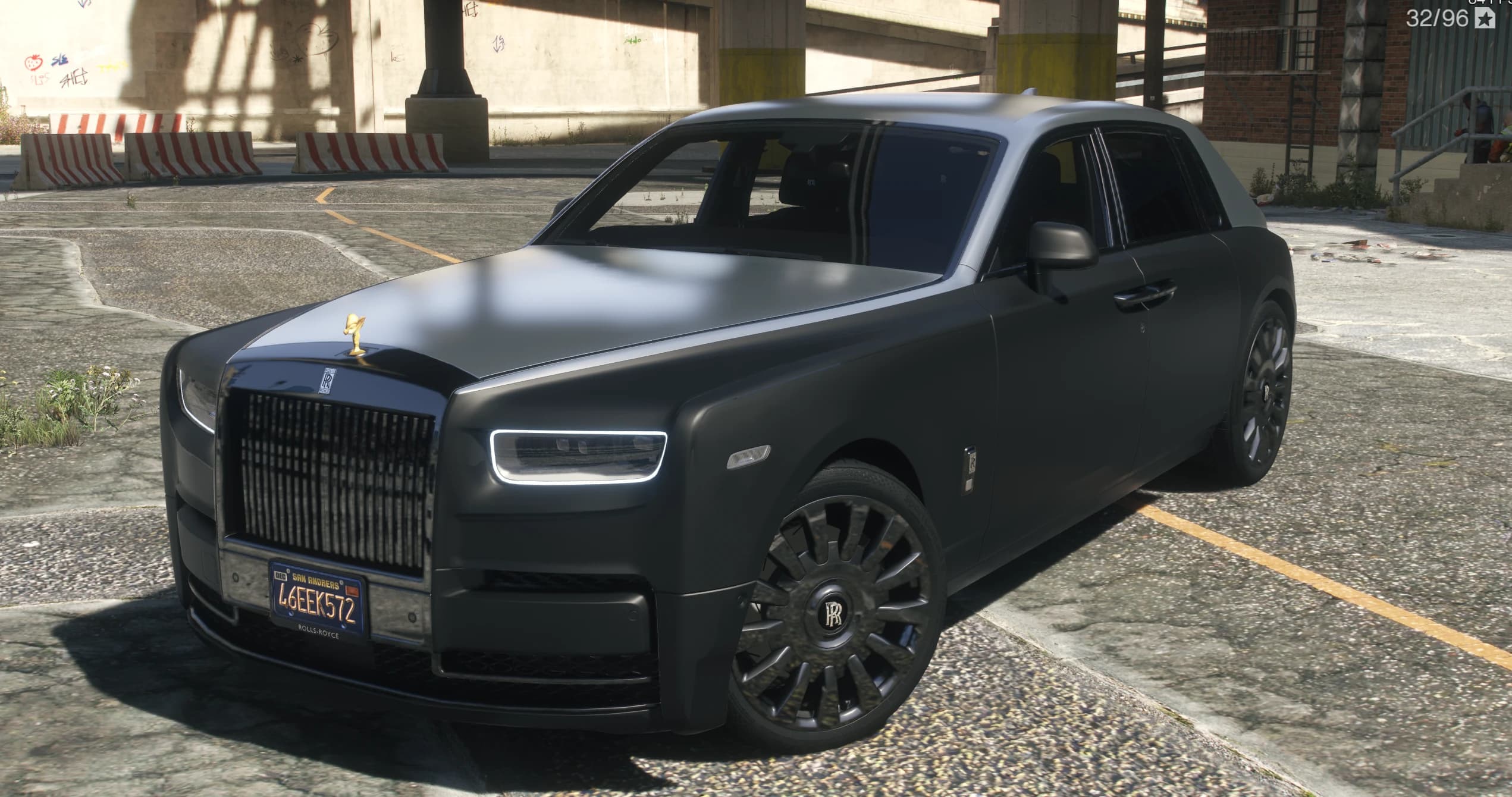 Front three quarter view of the satin black Phantom VIII with the silver bonnet and roof and the gold Spirit of Ecstasy