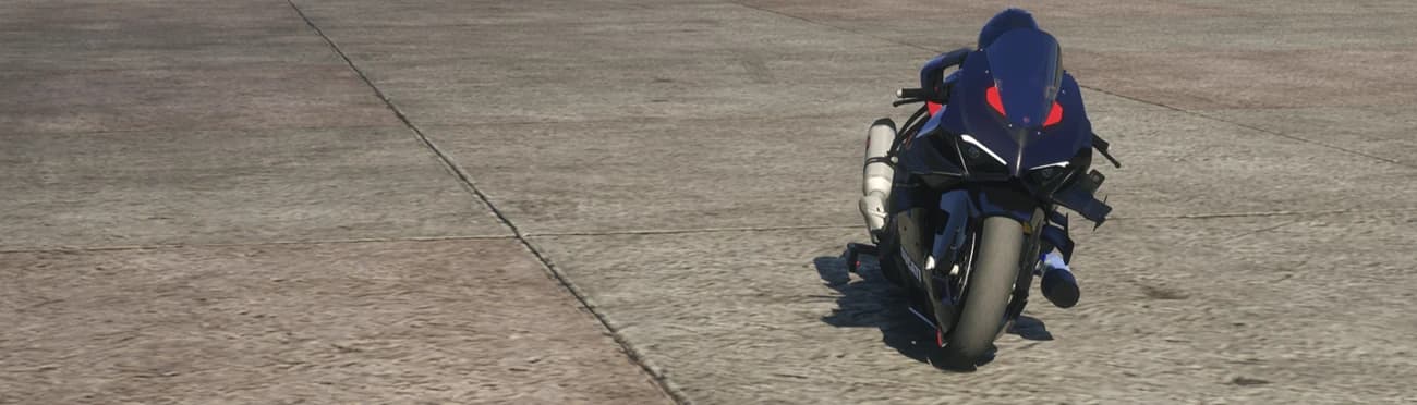 Distant front view of the dark Ducati V4 drag bike parked alone on empty airfield tarmac