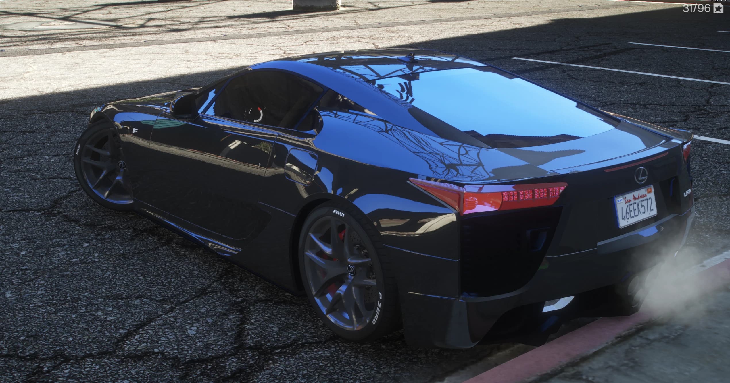 Rear three quarter view of the black LFA with the active wing sitting flush, red taillights and P Zero lettered tyres