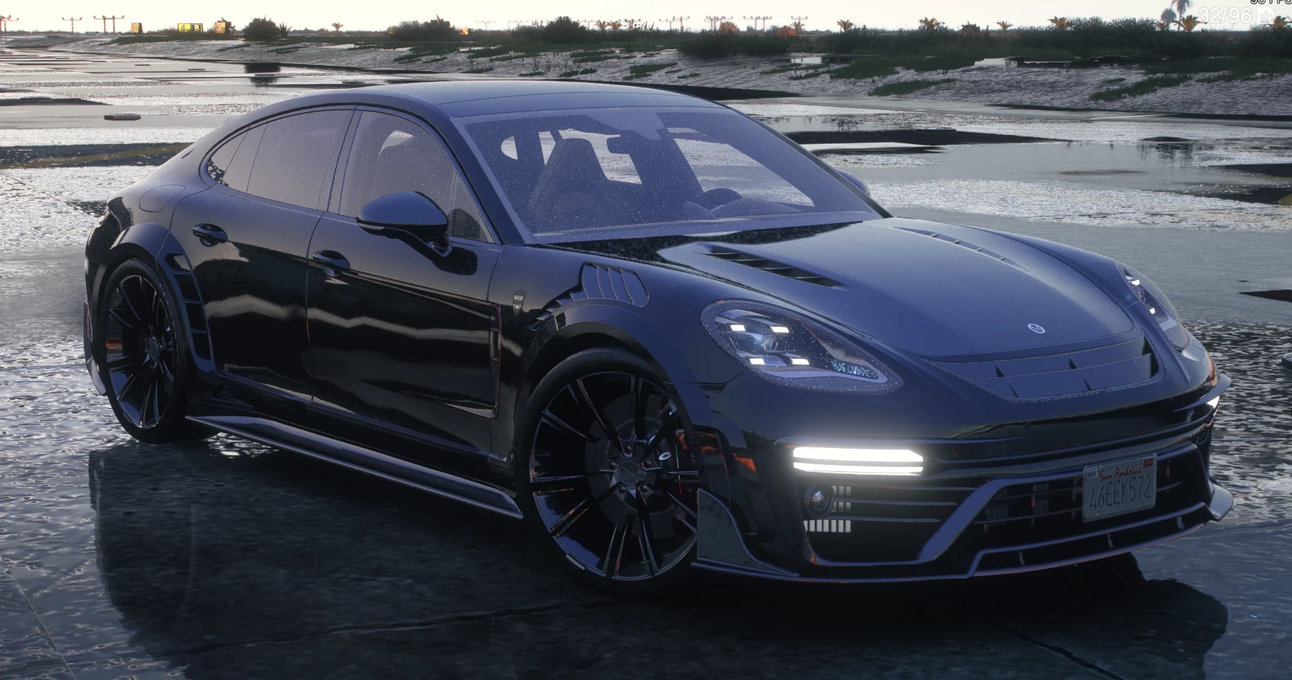 Front three quarter view of the black Mansory Panamera on wet tarmac with vented hood, louvred front fenders and lit LED strips in the bumper