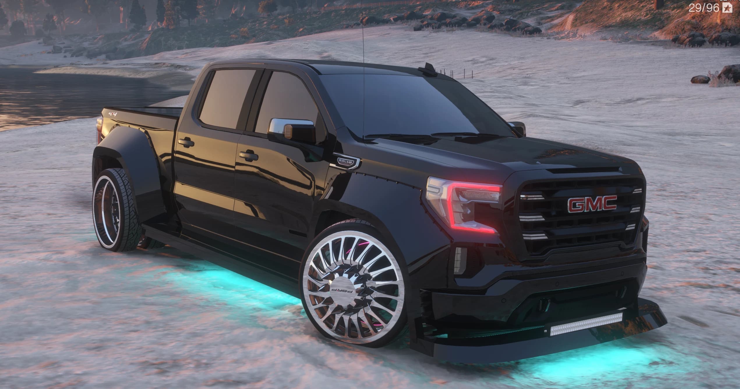 Black custom widebody GMC Sierra dually pickup, front three-quarter, lowered on chrome multi-spoke dually wheels with cyan underglow, a front splitter light bar and the red GMC grille badge