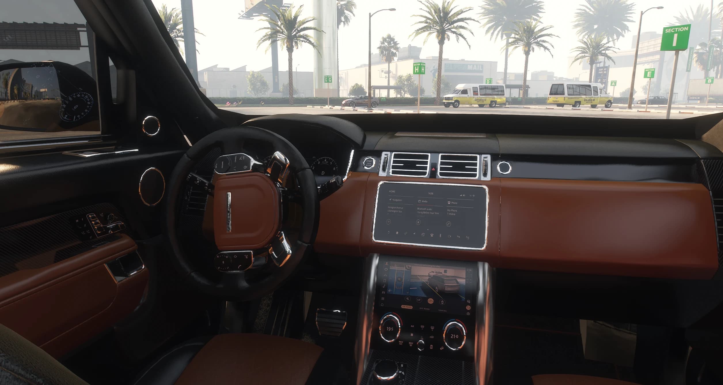 Interior of the Range Rover with tan and black leather, the dual center screens and camera view active