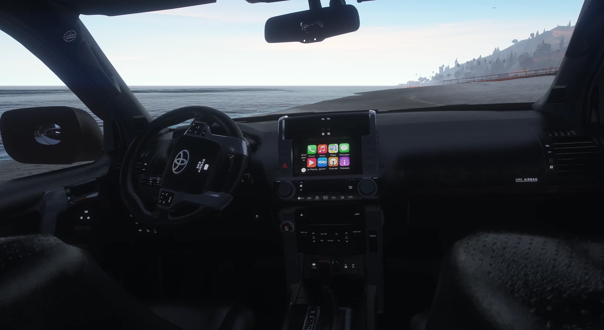 Interior of the Prado with the Toyota steering wheel and the central touchscreen showing a CarPlay style home screen