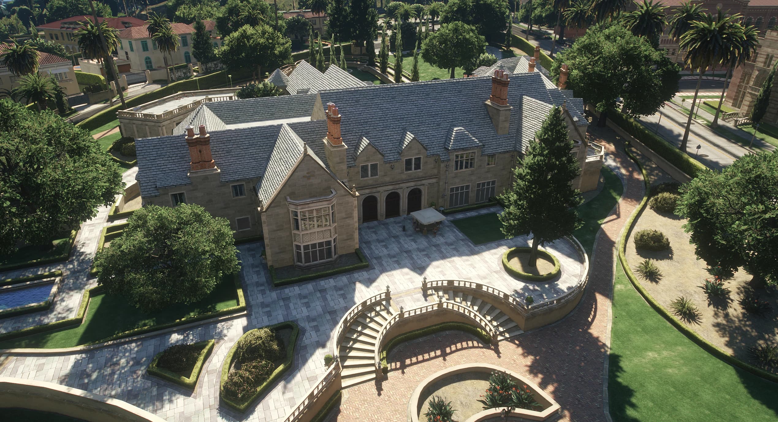 Aerial view of the estate with the Tudor style mansion, gardens and curved stairways
