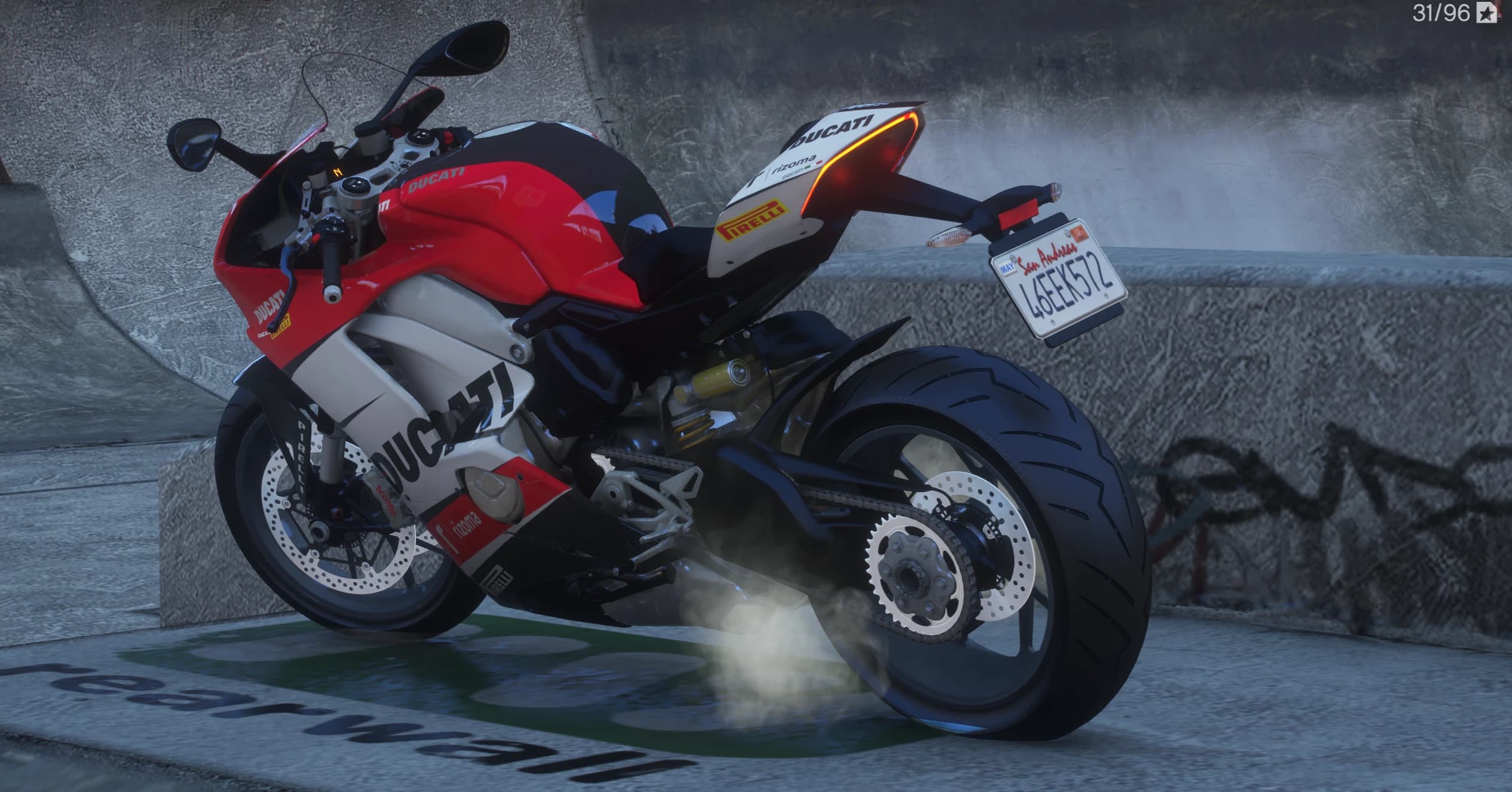 Rear three quarter view showing the race tail with a lit red LED edge, chain and sprocket detail and a San Andreas plate