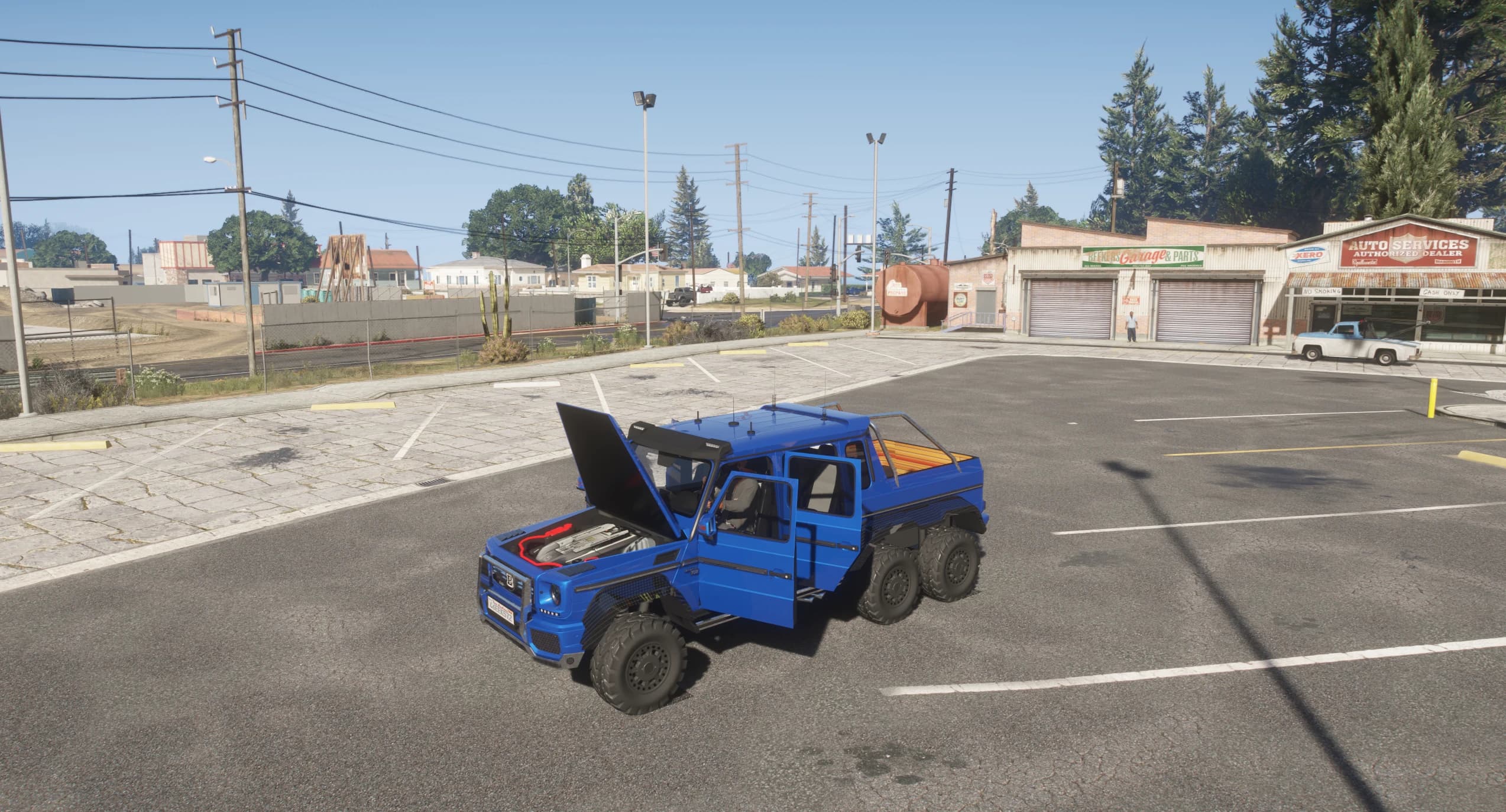 The G63 6x6 with its bonnet and door open in a parking lot, exposing the modelled engine bay