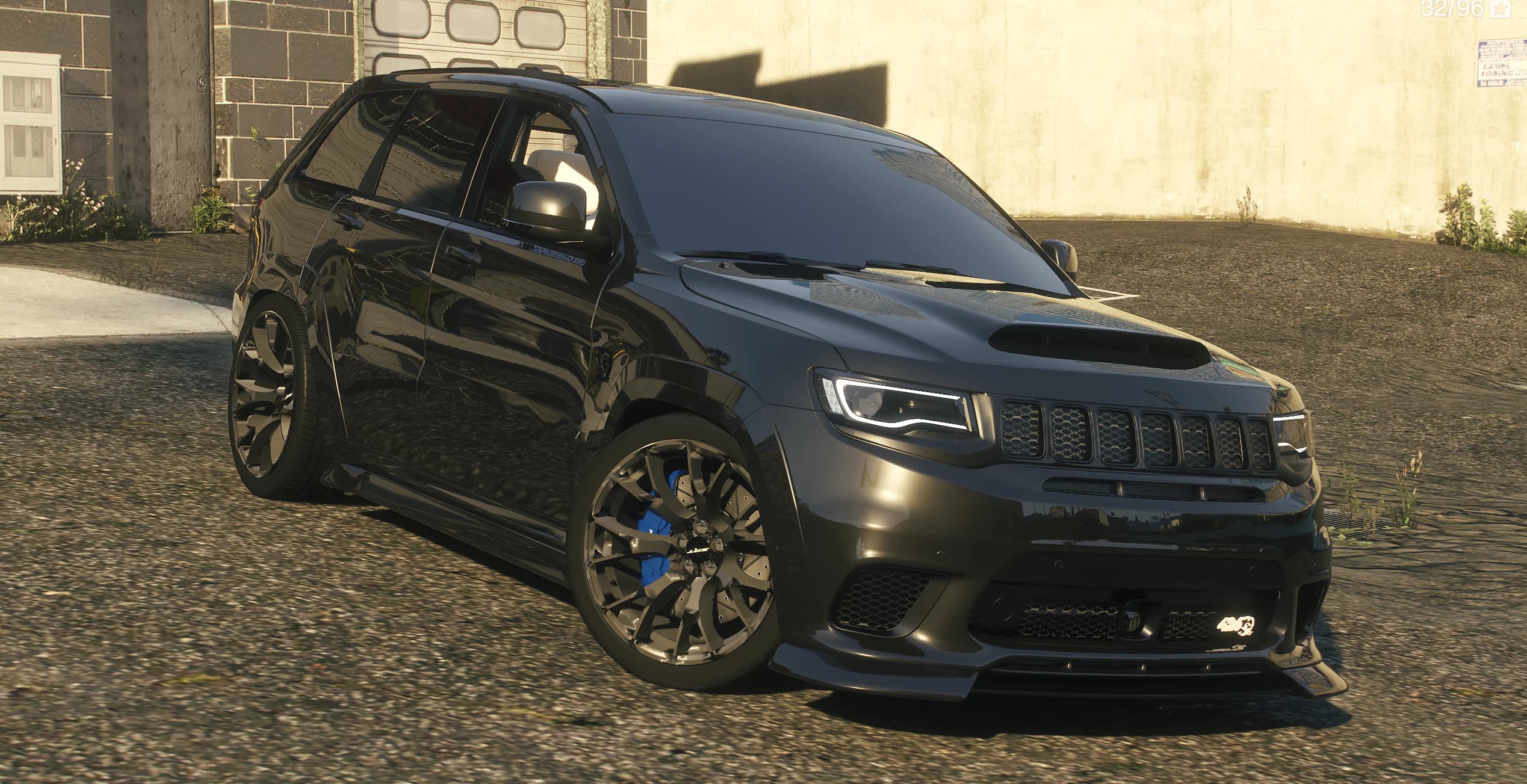Front three quarter view of the black Trackhawk with the hood scoop, black wheels and blue calipers