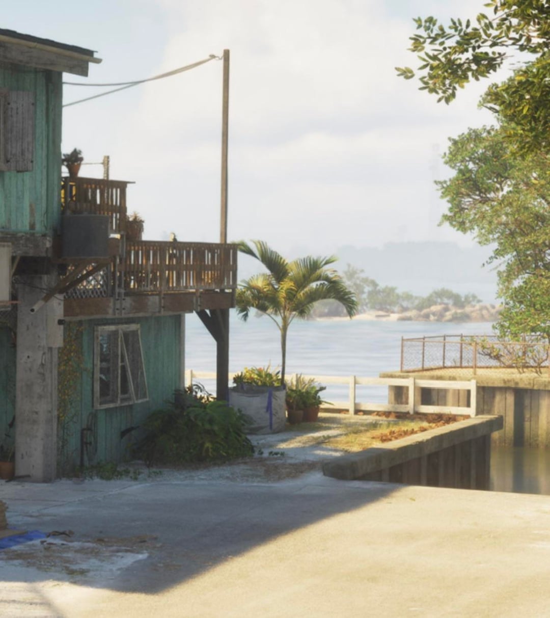 Later GTA 6 shot of the same stilt house from the driveway, now with a wooden post and rail fence along the water's edge