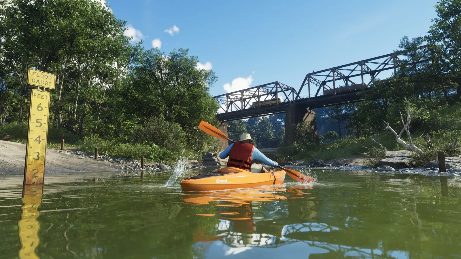 A player paddling an orange kayak down a river in Mount Kalaga National Park, past a water-level gauge with a steel rail bridge in the background
